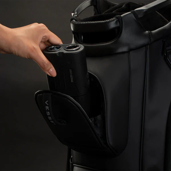 Model putting a black rangefinder into the upper magnetic rangefinder pocket of a black lux cart bag