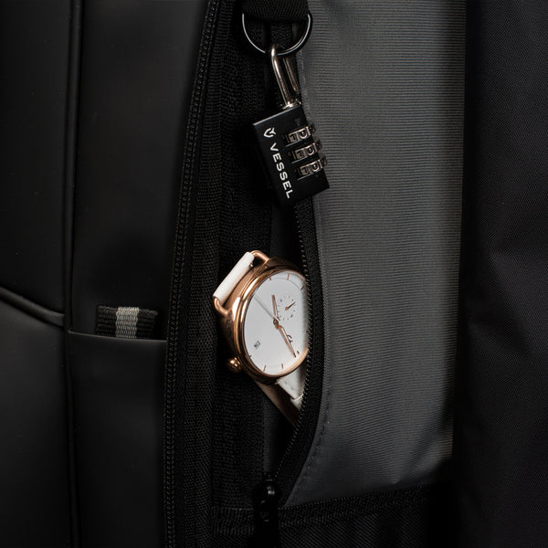 A white and rose gold watch in the personals pocket of a black lux cart bag
