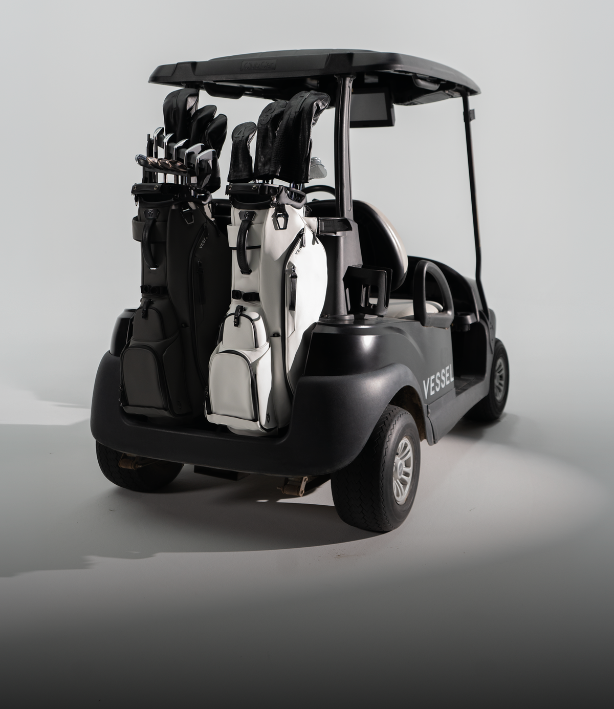 Two player VI Series stand bags on the back of a black golf cart