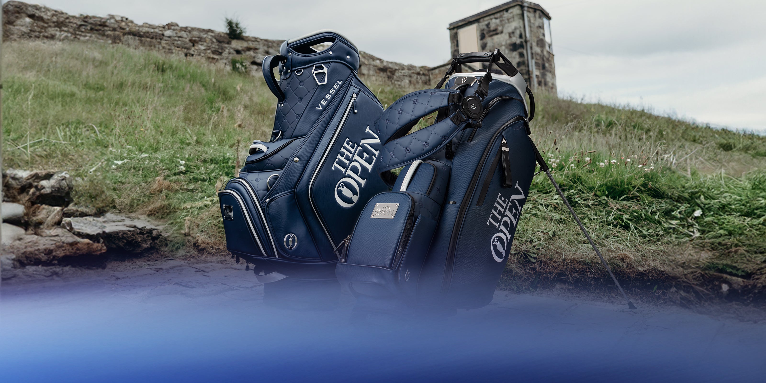 Golf bag with 'The Open' branding on a grassy field with ruins in the background