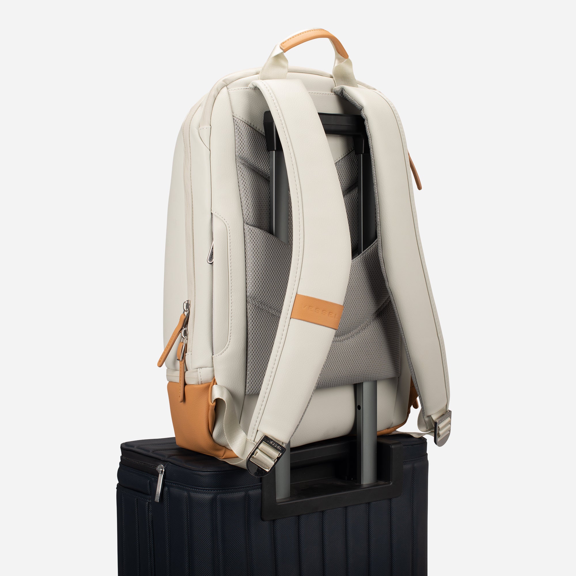 Latte Signature Backpack sitting on top of suitcase #color_latte