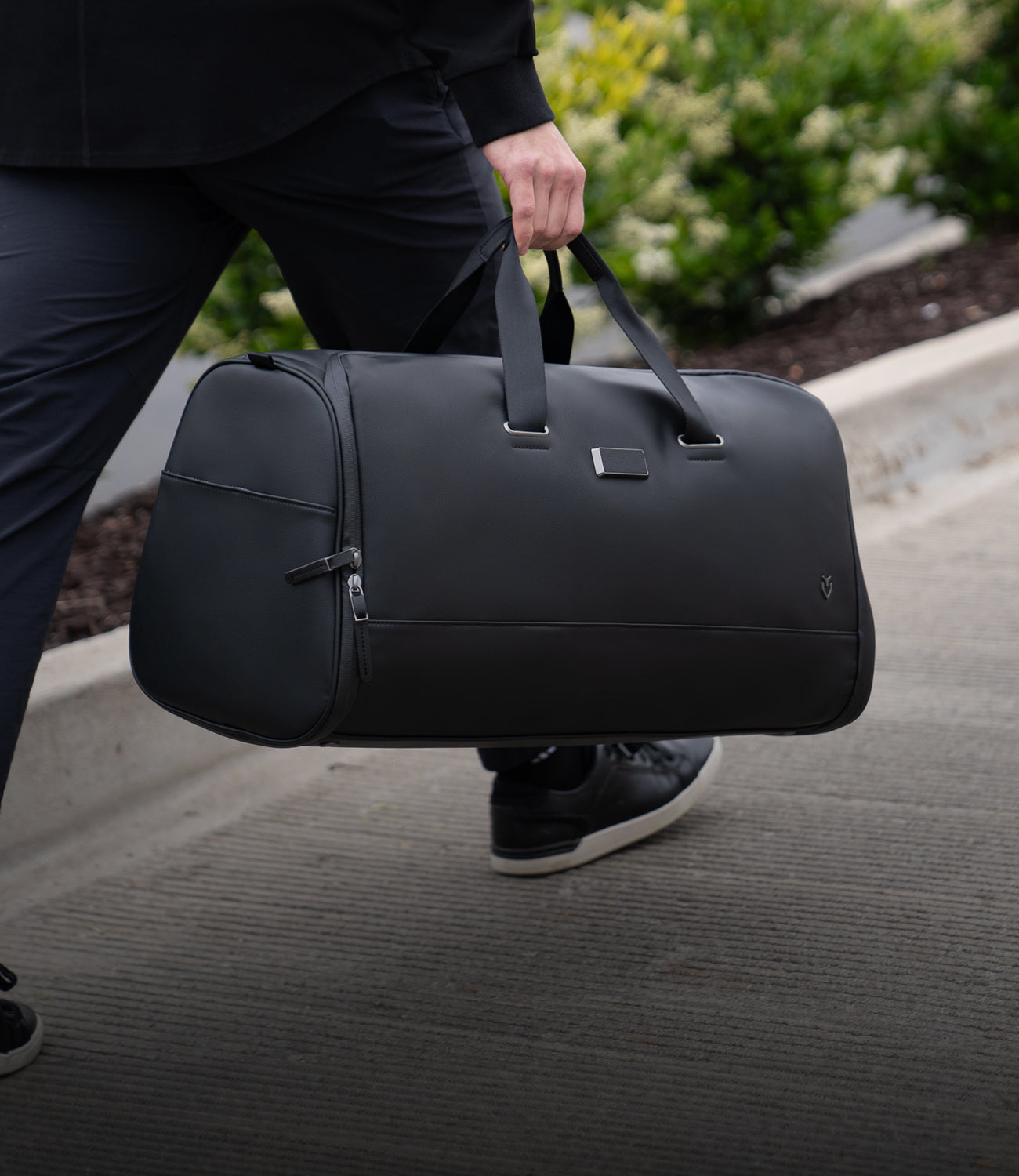 Model carrying black signature garment duffel