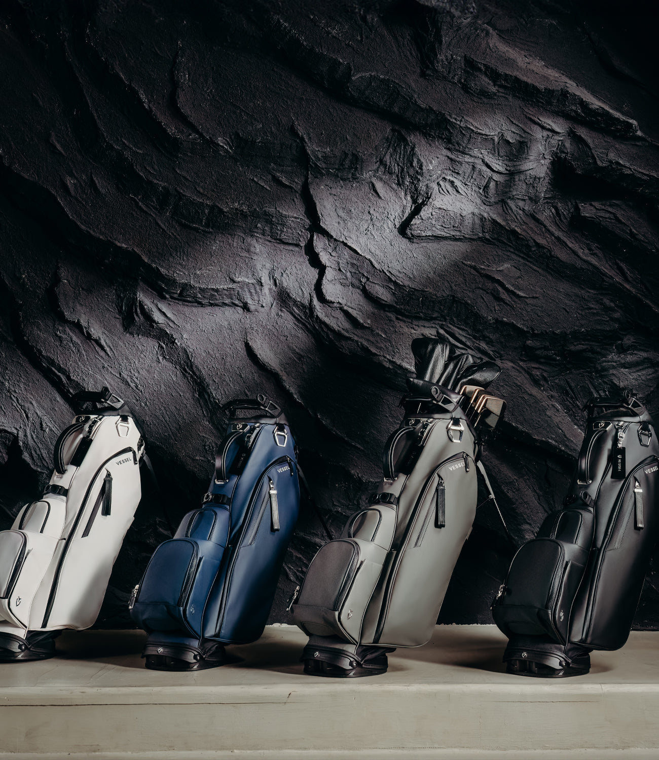 4 golf stand bags next to each other: White, Navy, Grey, Black.