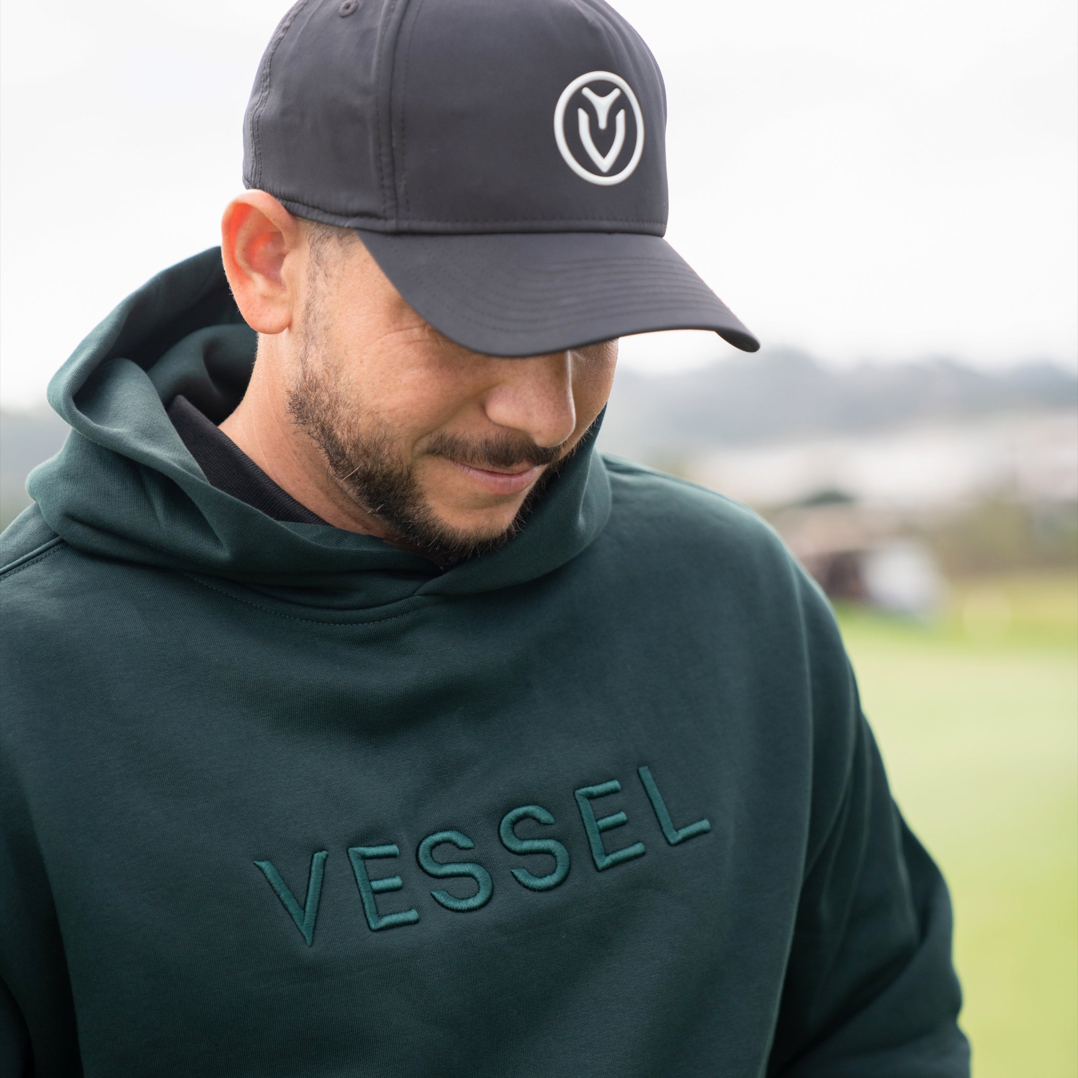 Man outside wearing green VESSEL Hoodie #color_green