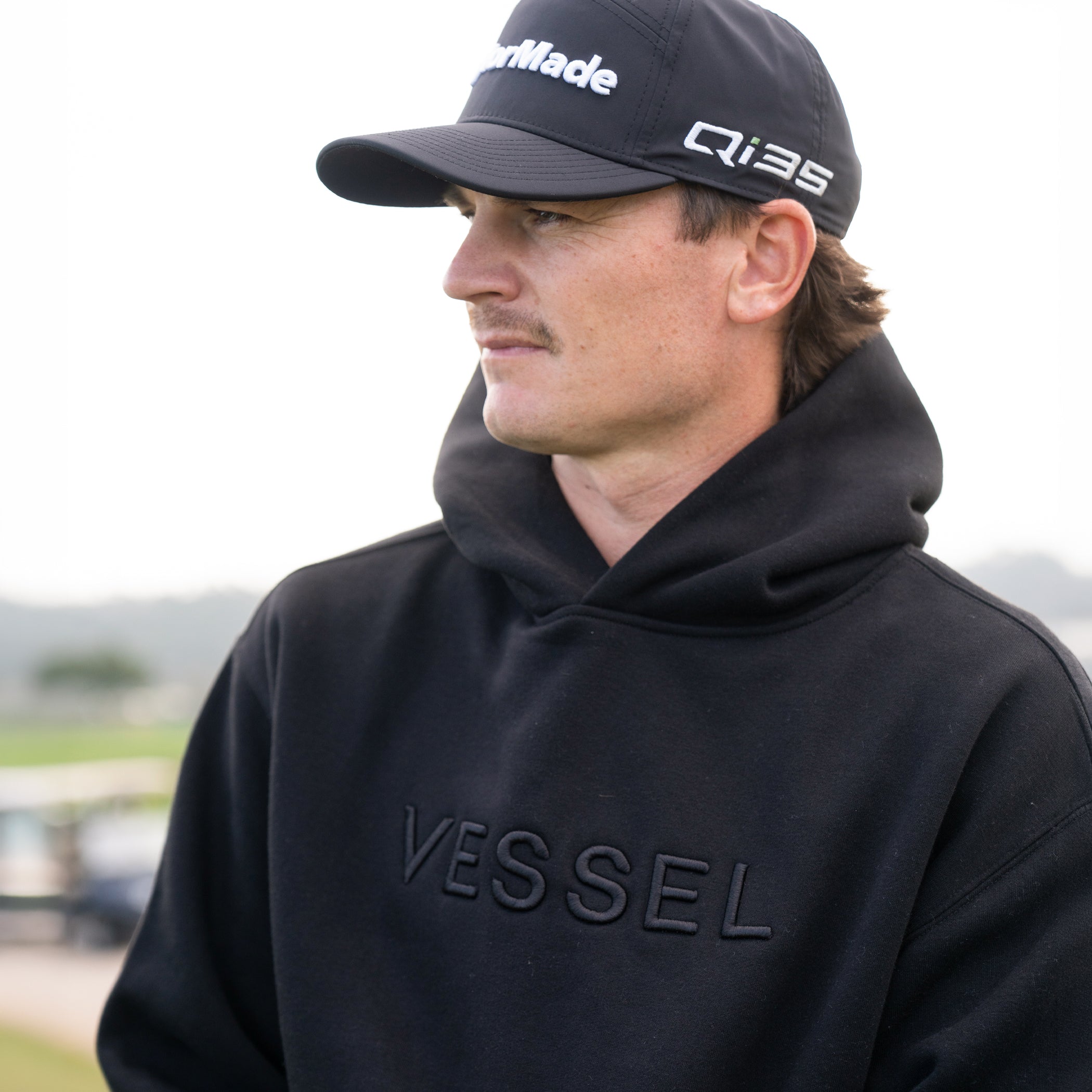 Man outside wearing black VESSEL Hoodie #color_black