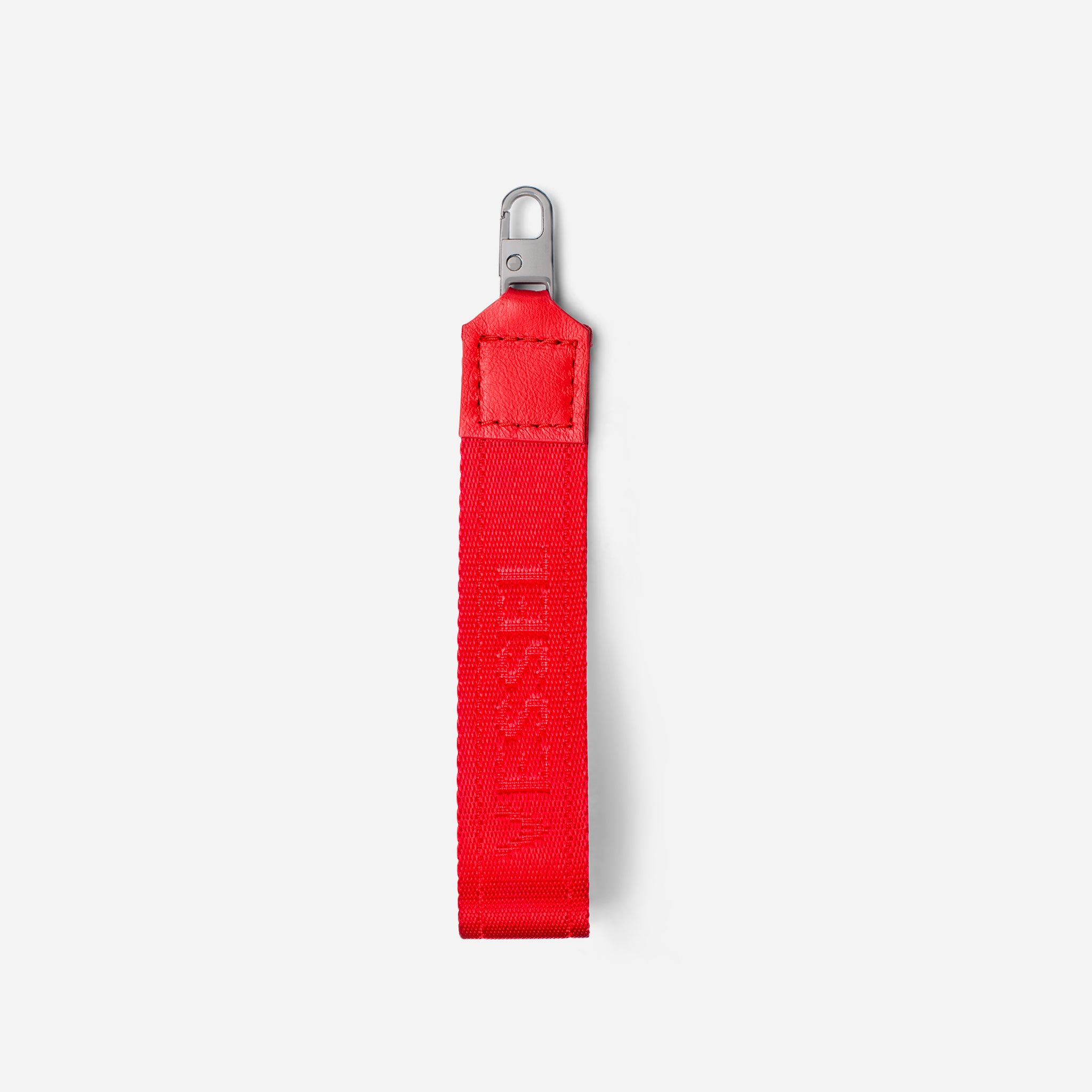 Red jacquard fabric loop zipper pull against a white background