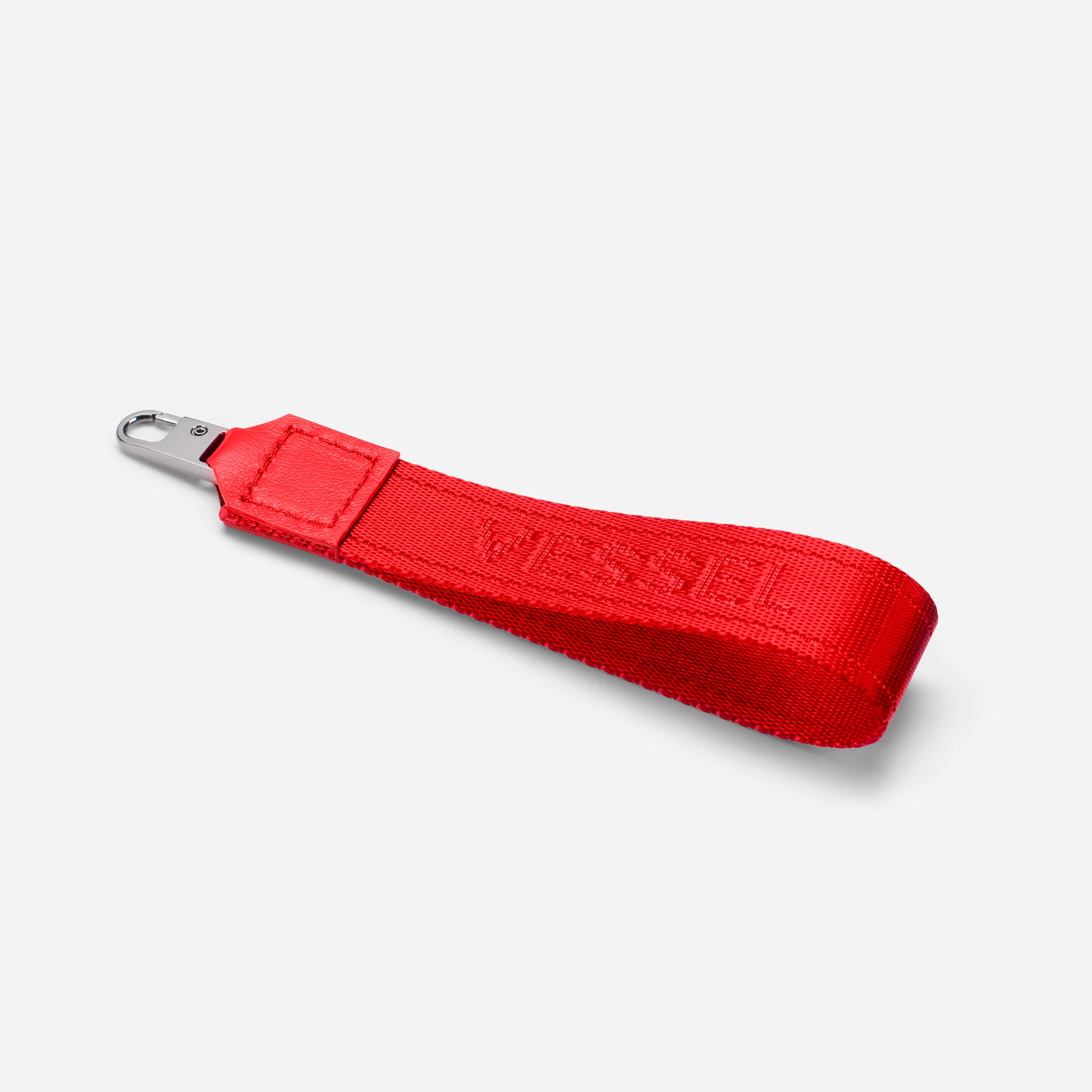 Red jacquard fabric loop zipper pull against a white background at an angle