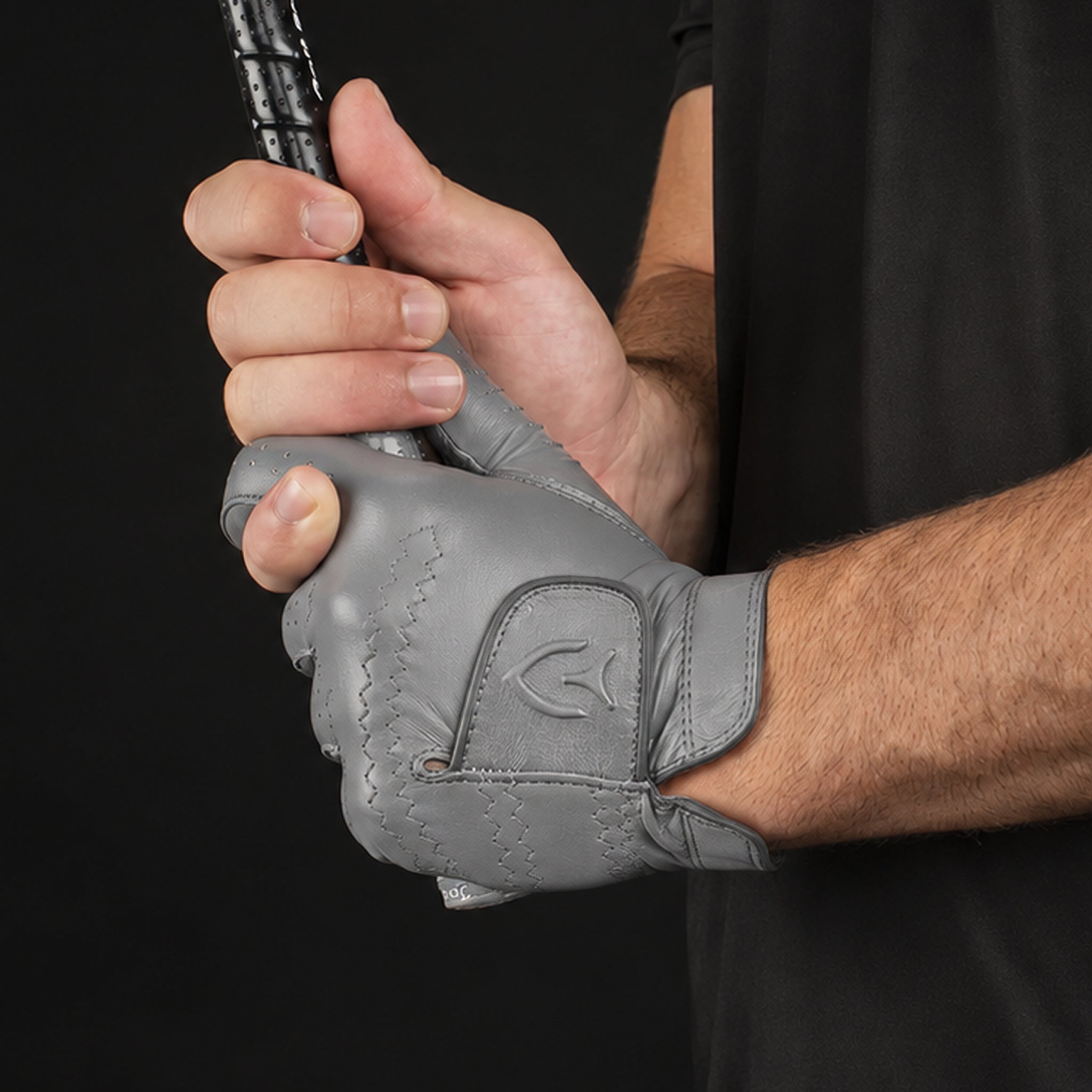 Man wearing grey golf glove while holding a club