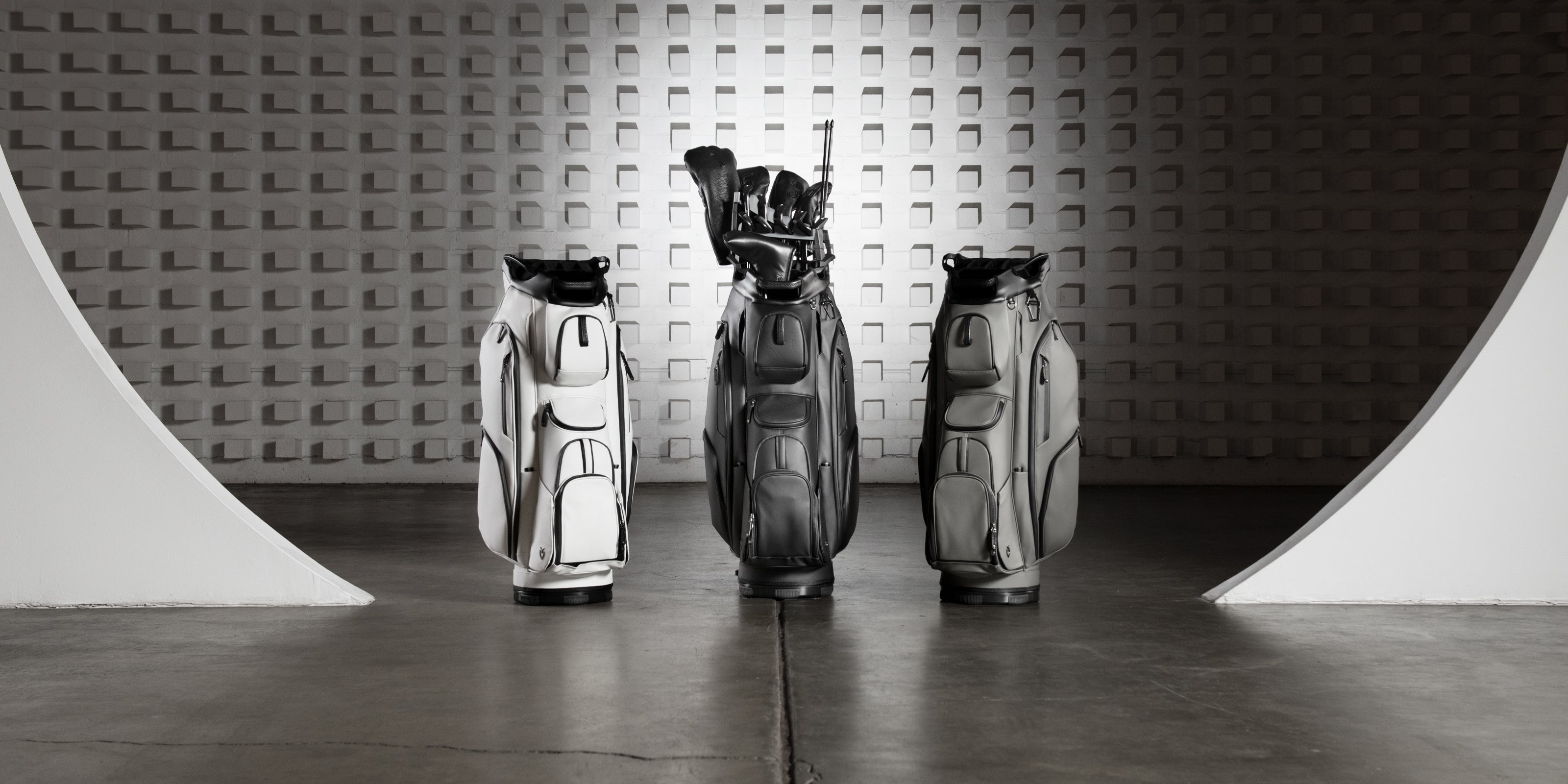 White, Black, and grey golf cart bags in large warehouse