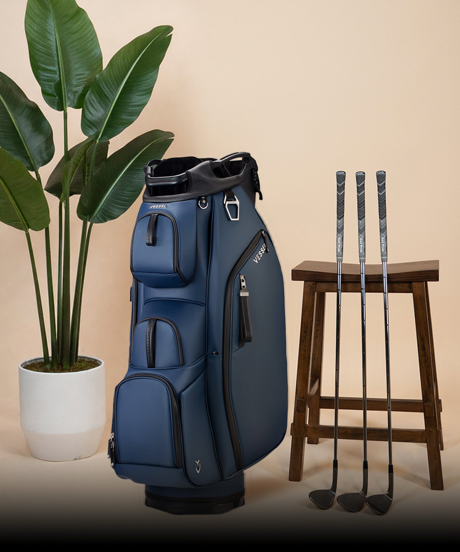 Navy Lux Pro Cart next to potted plant and three golf clubs