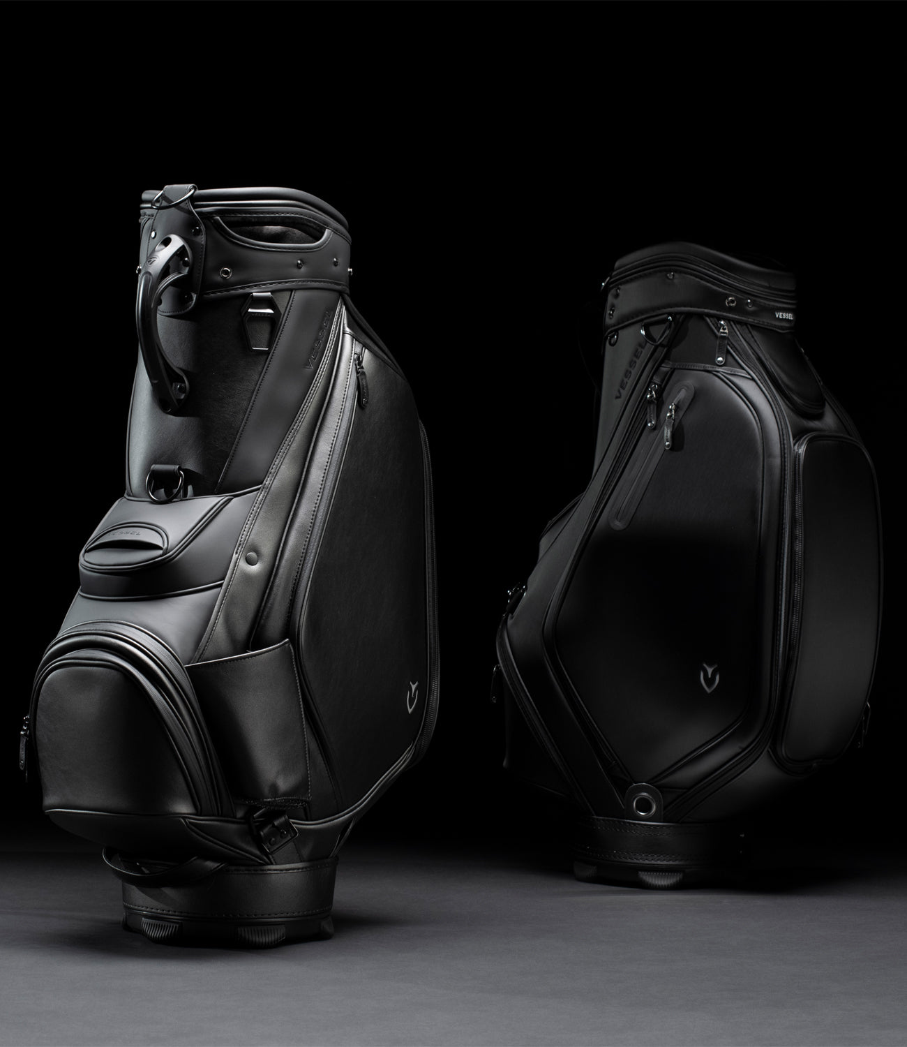 Two black leather staff bags on a black background