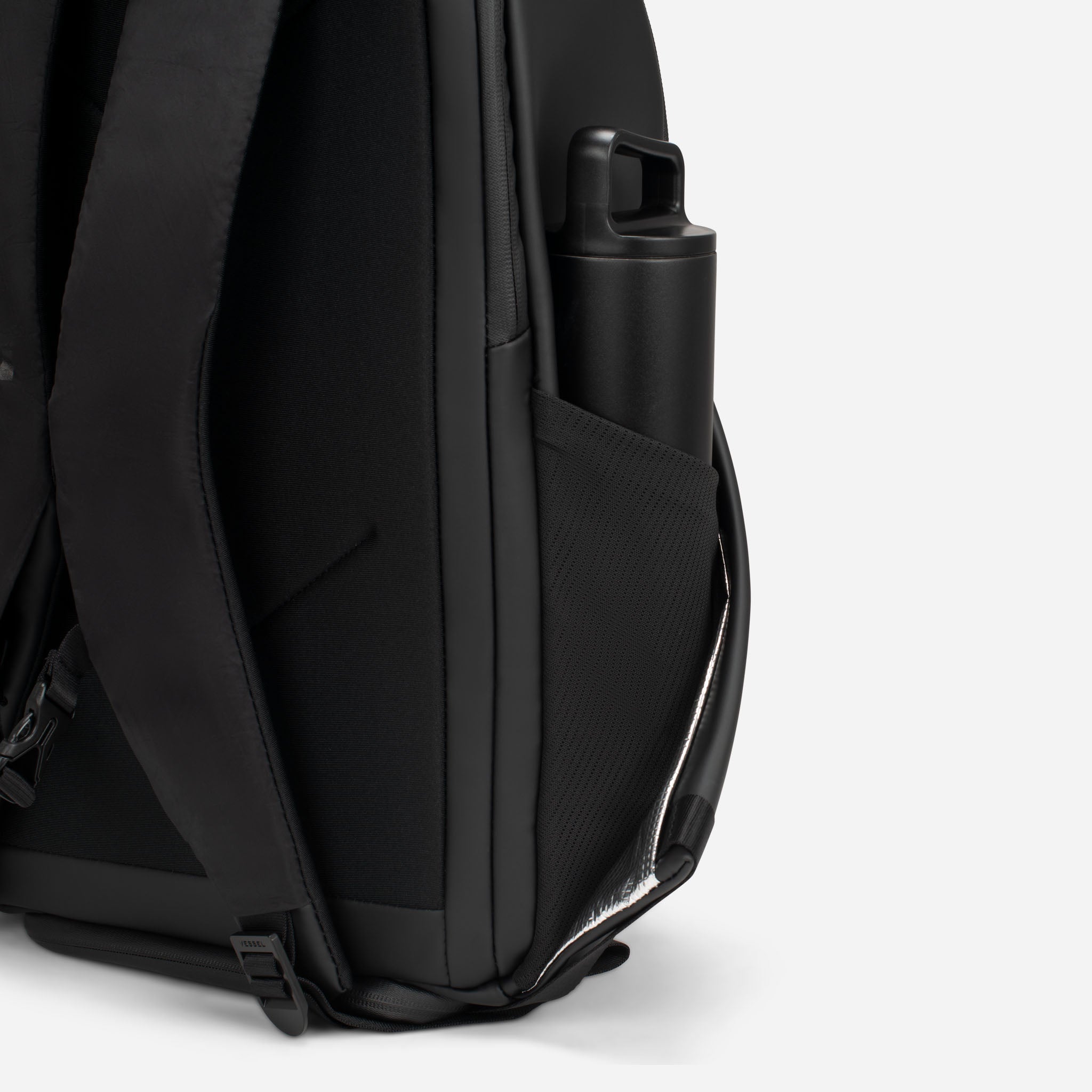 Close up of black tennis backpack side watter bottle pocket with black water bottle inside
