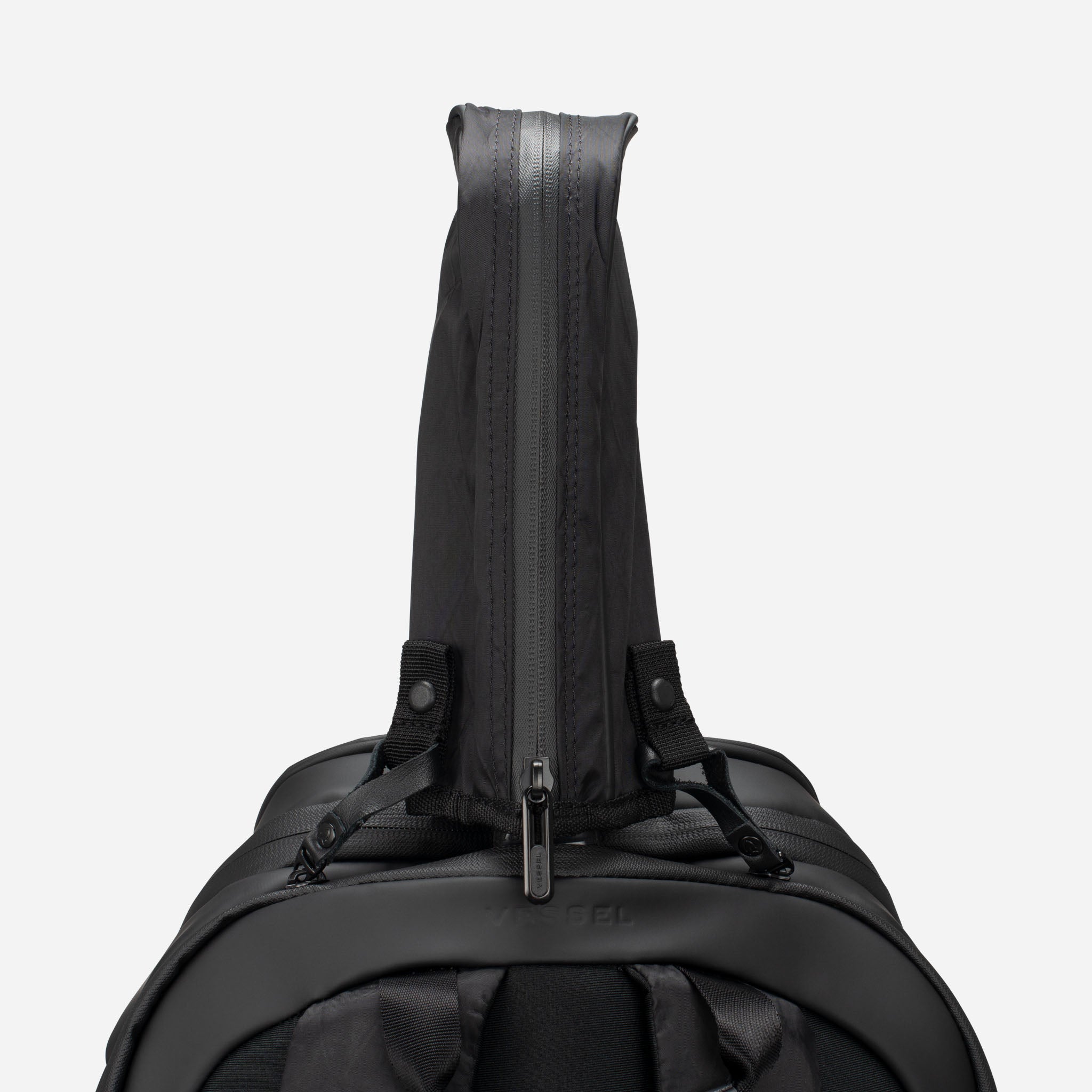 Black tennis racquet handle cover sticking out of black tennis backpack