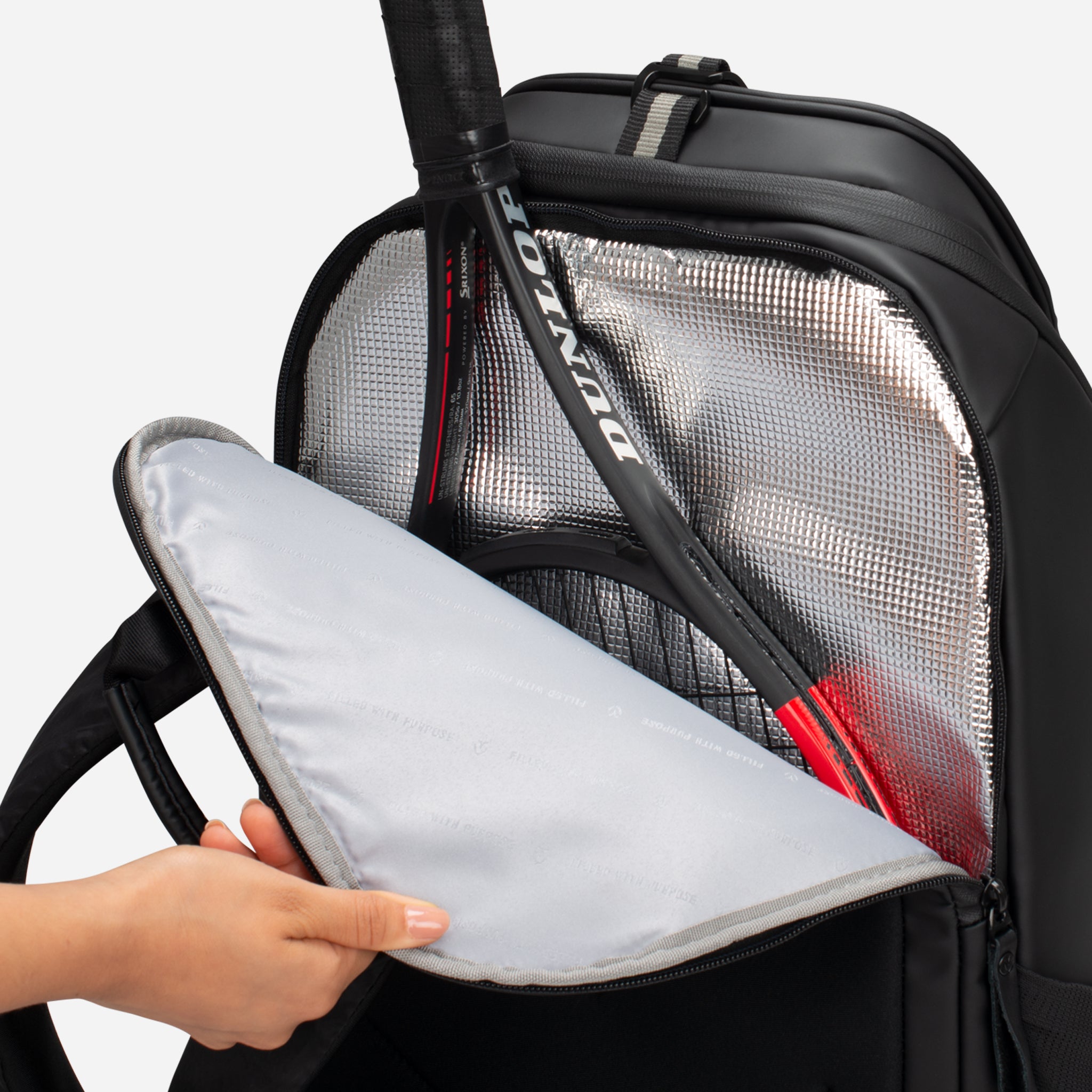 Back pocket of black tennis backpack being open to reveal the thermal lined inside and black tennis racquet