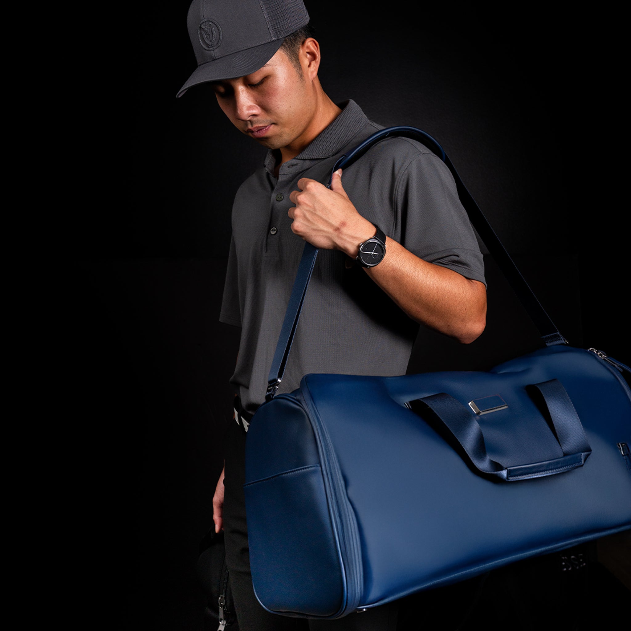 Man carrying Navy Signature Garment duffel #color_Pebbled Navy