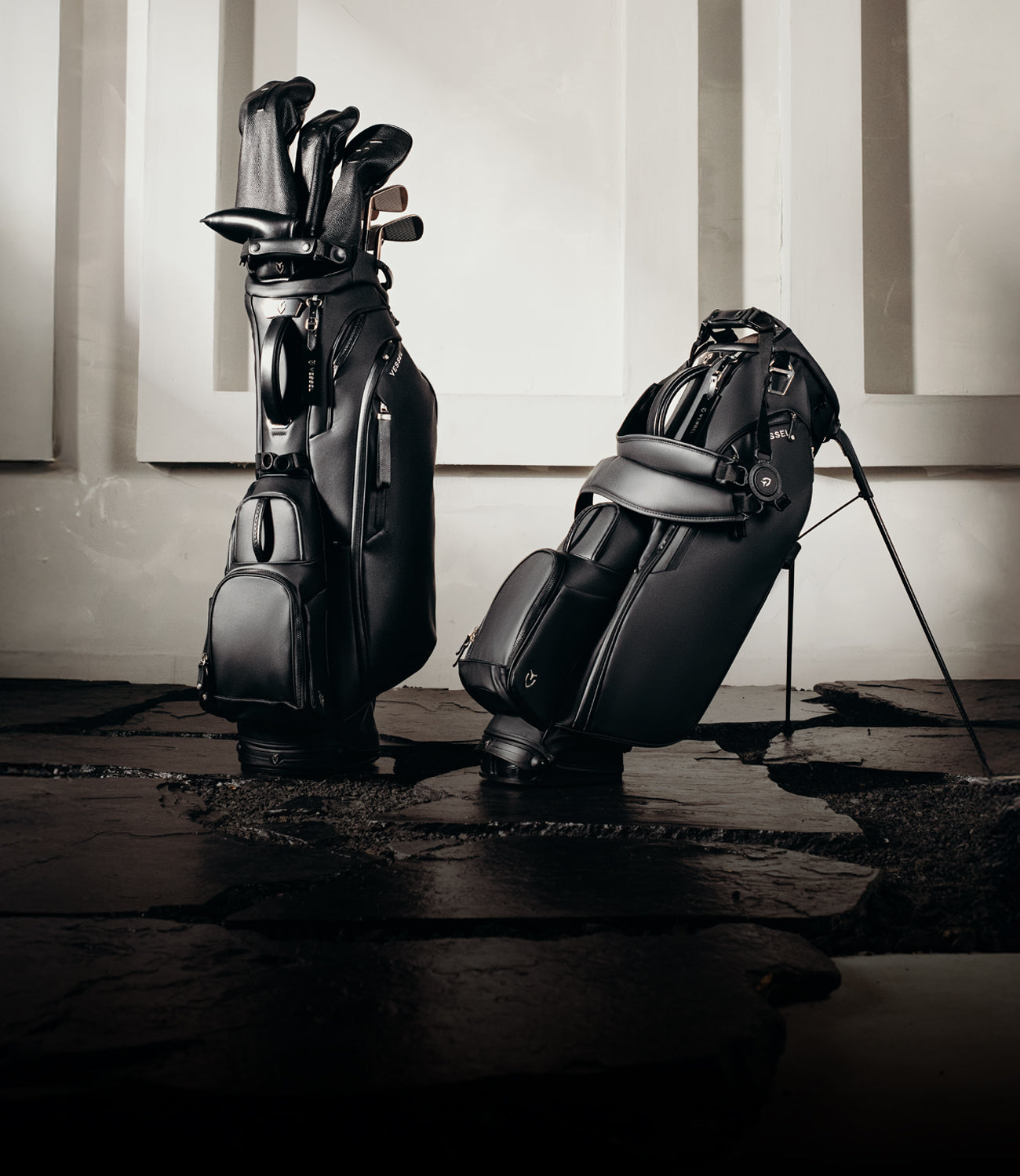 Two black golf stand bags on a flagstone path