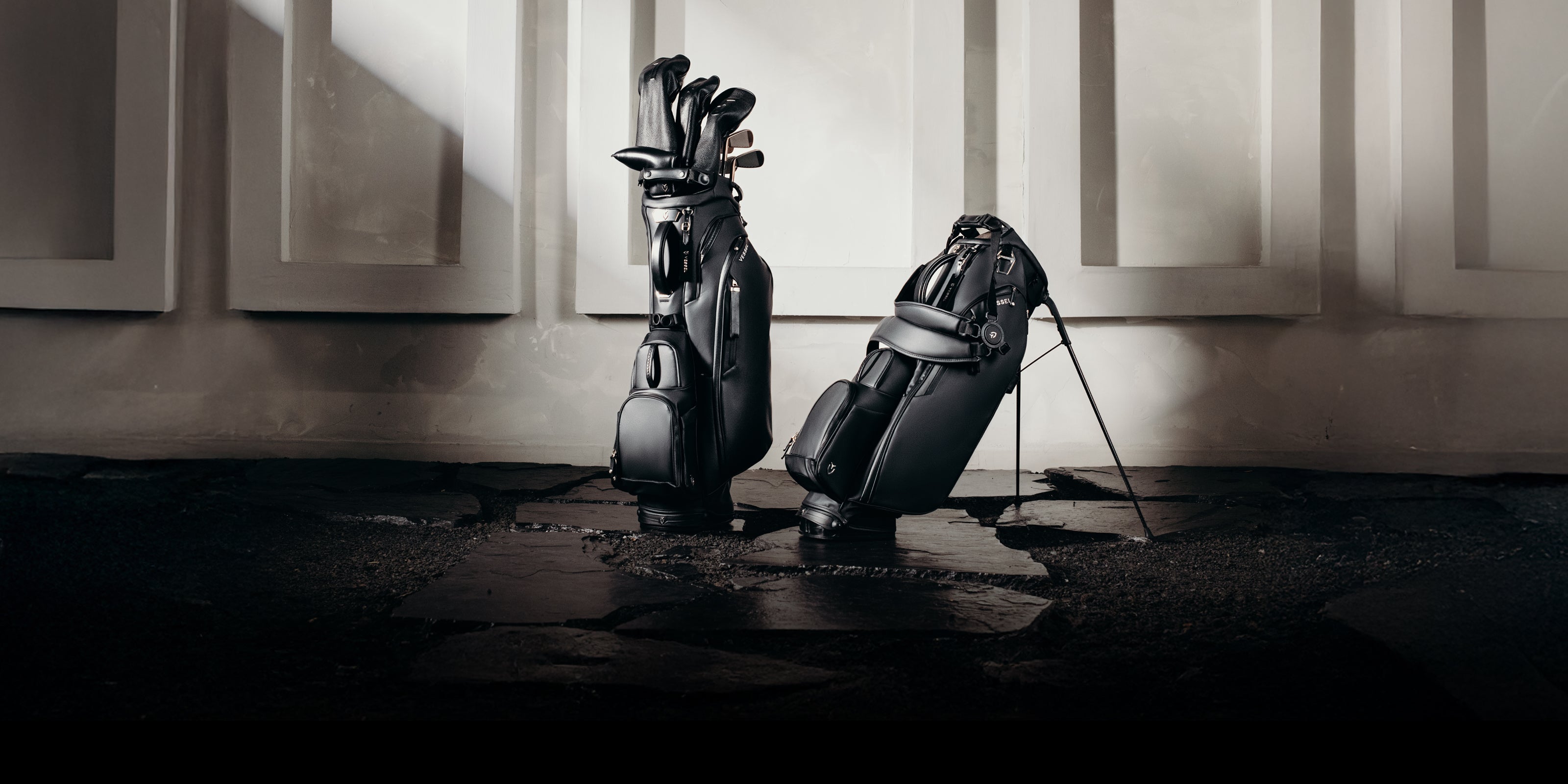 Two black golf stand bags on a flagstone path
