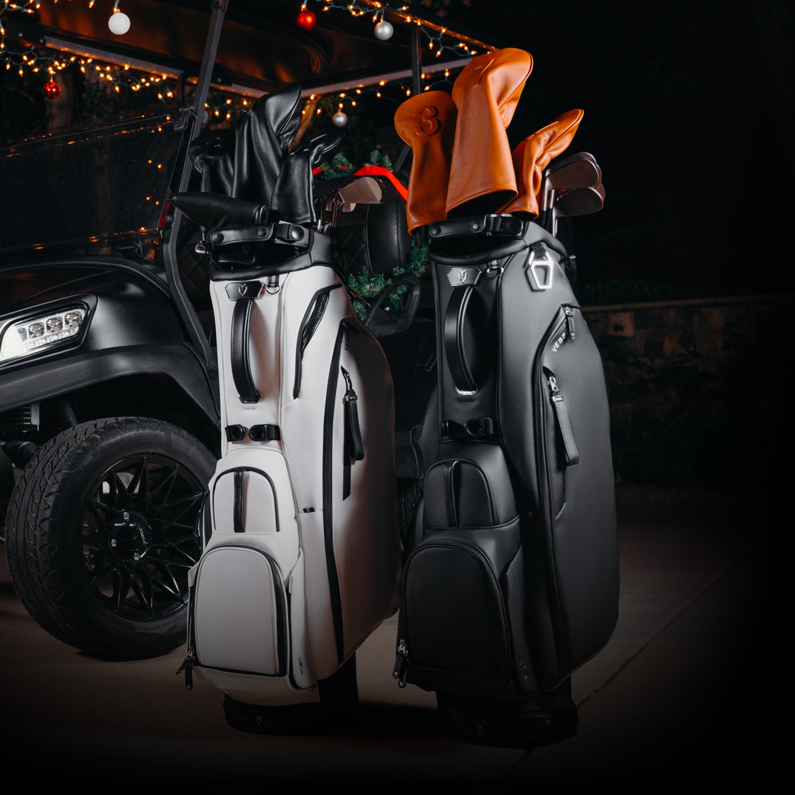 Black and white golf stand bags next to golf cart, Christmas decor