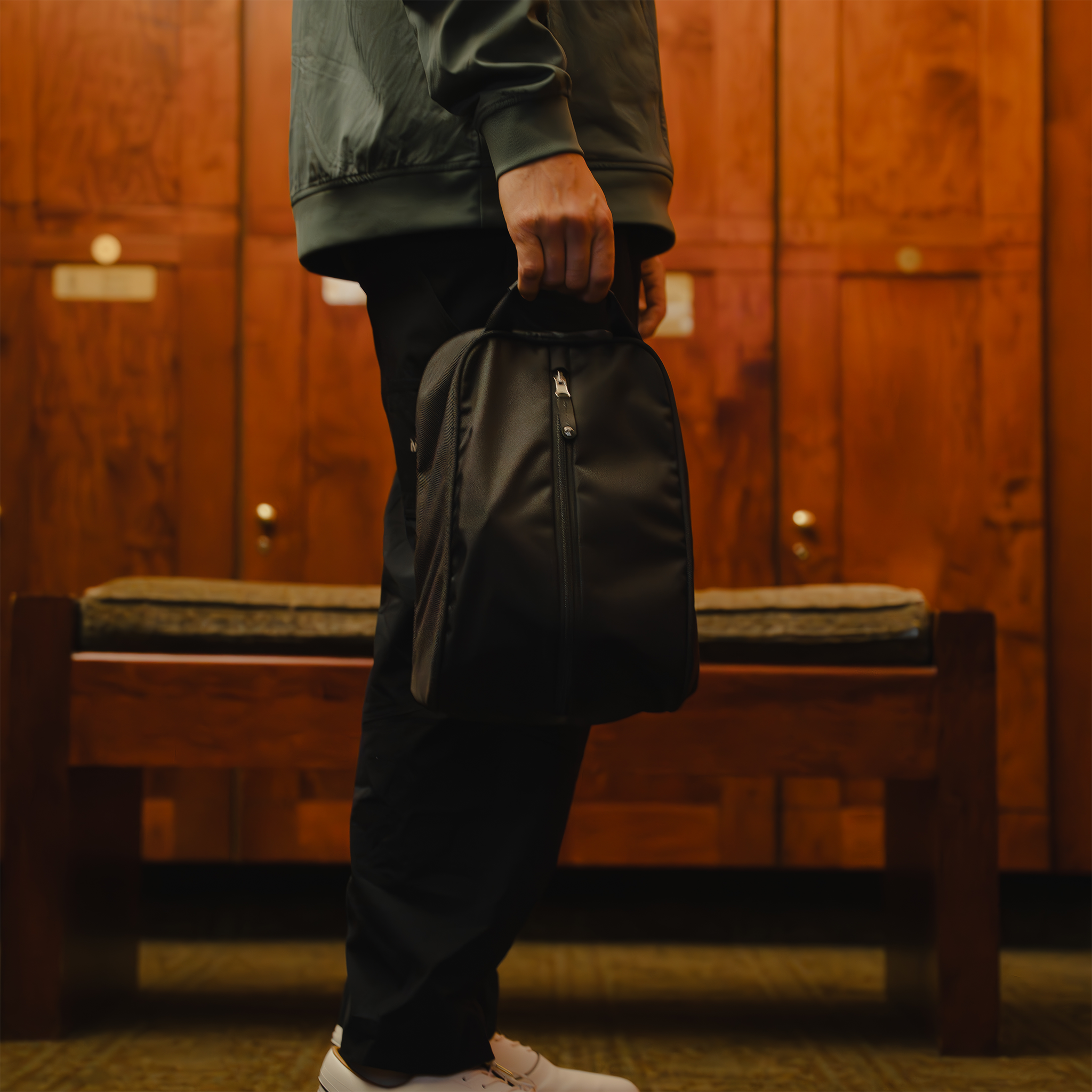 man holding packed up sunday carry in a locker room