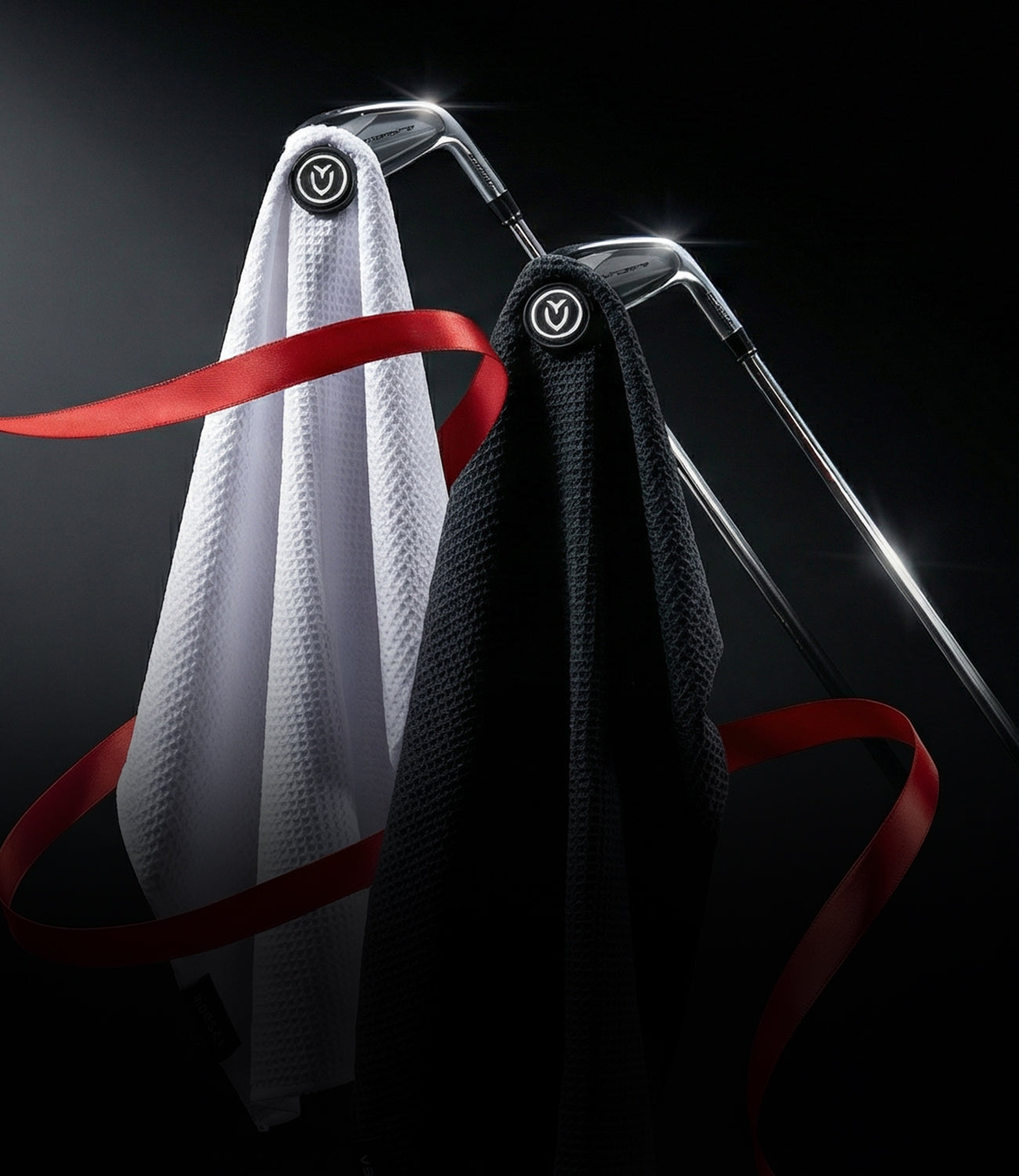 A White and a black magnetic golf towel wrapped loosely in red ribbon