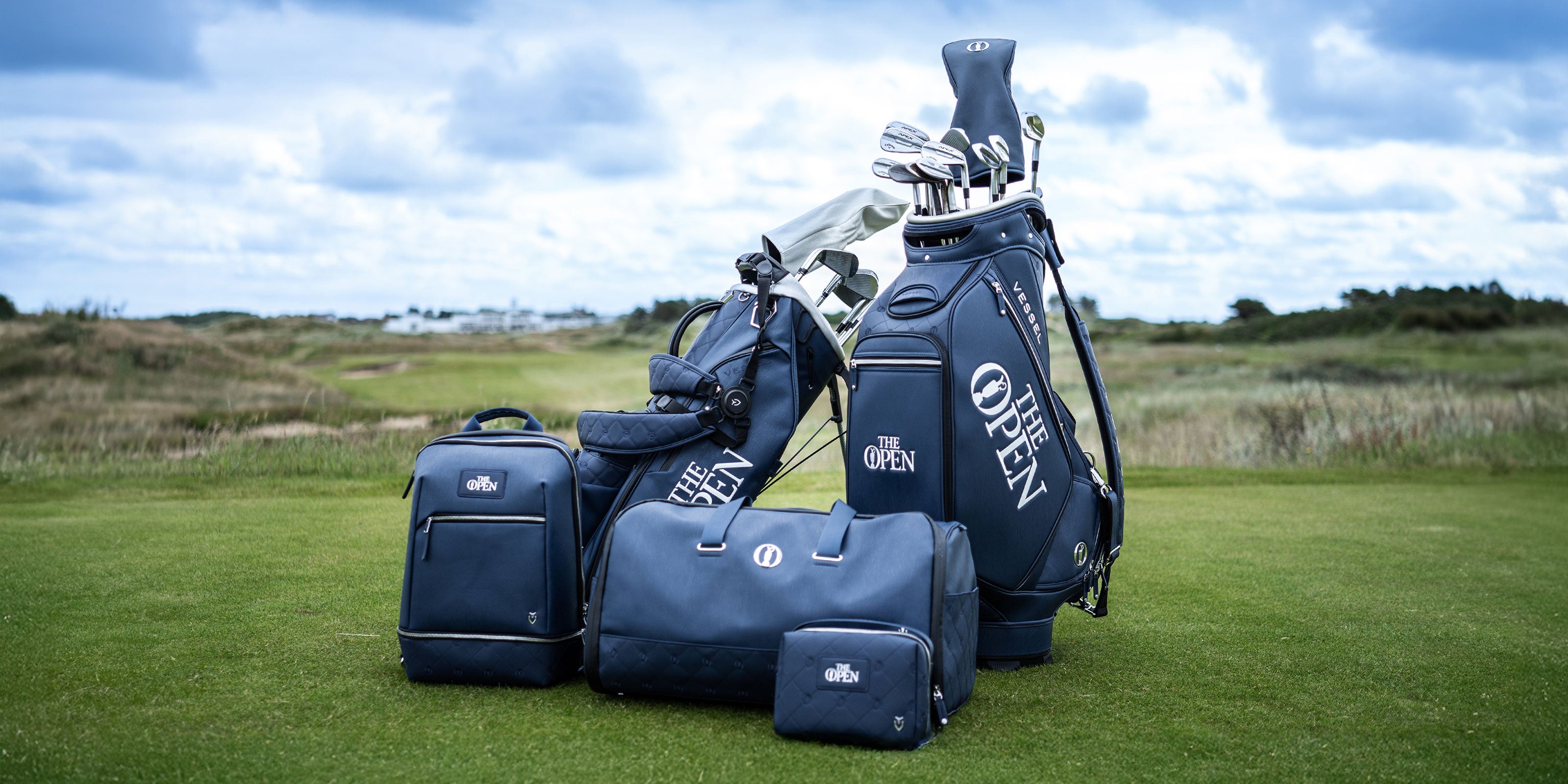 2 blue golf bags and 3 blue lifestyle bags on a golf course to celebrate The Open.