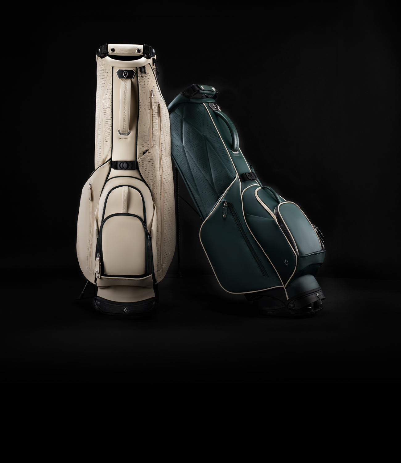 Two leather golf bags leaning against each other on a dark background