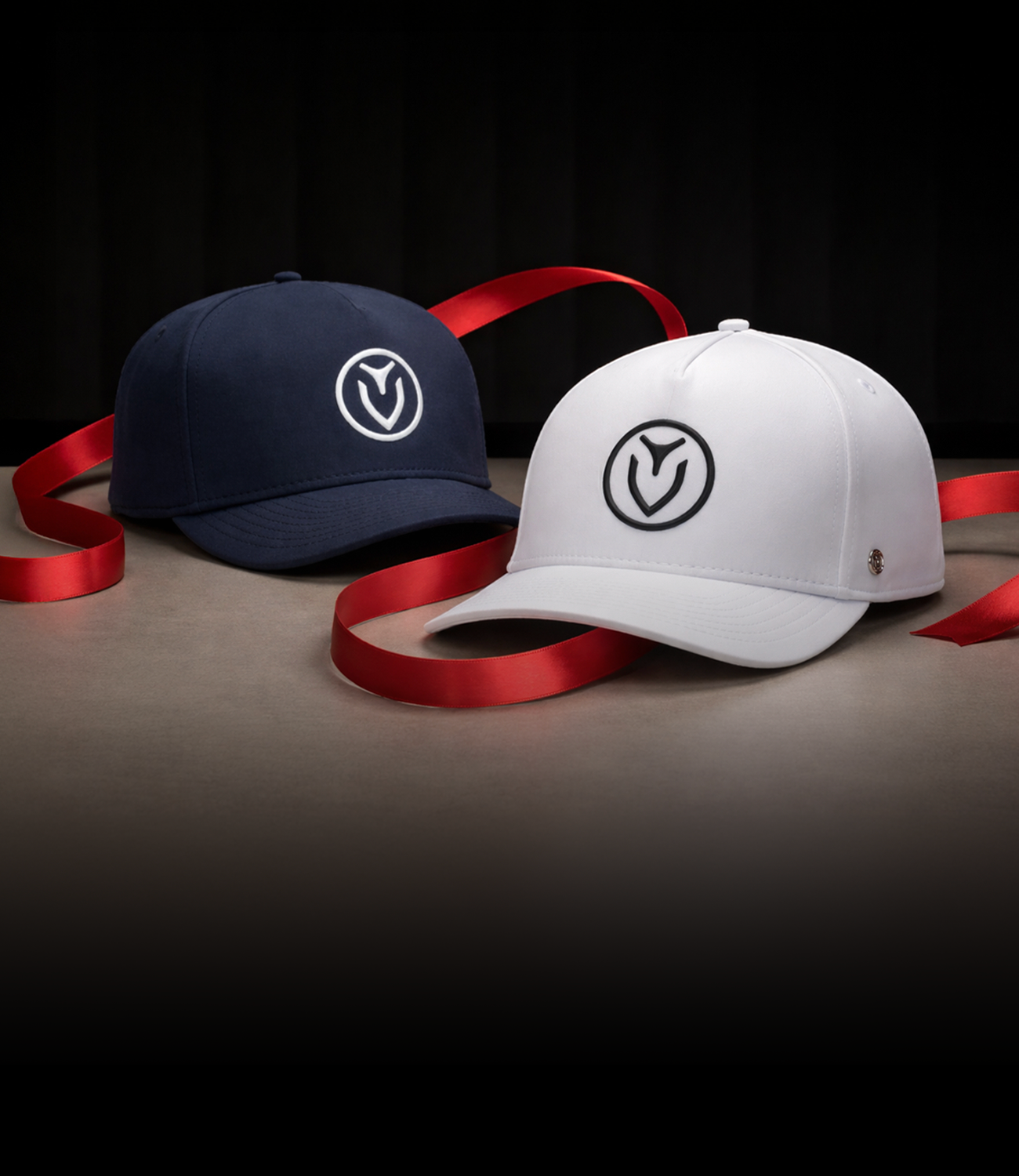 Navy hat and white hat wrapped loosely in red ribbon