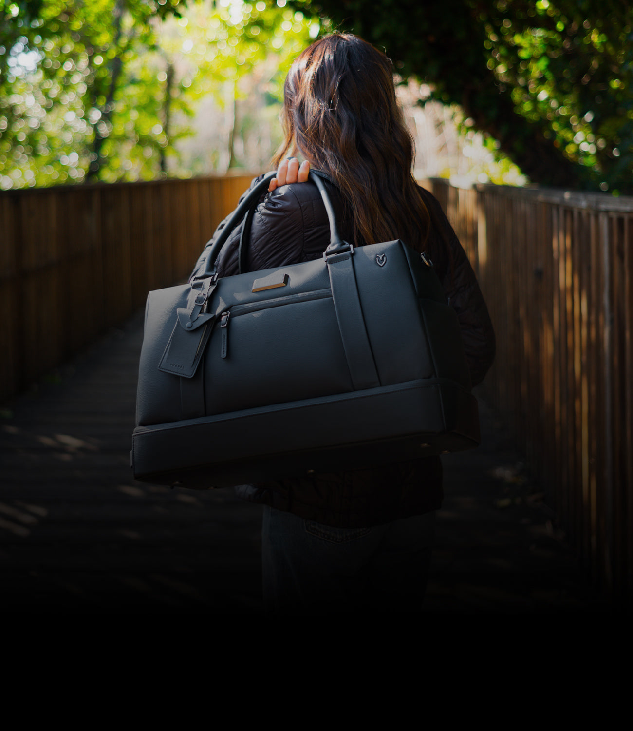 Woman with leather duffel bag over her shoulder