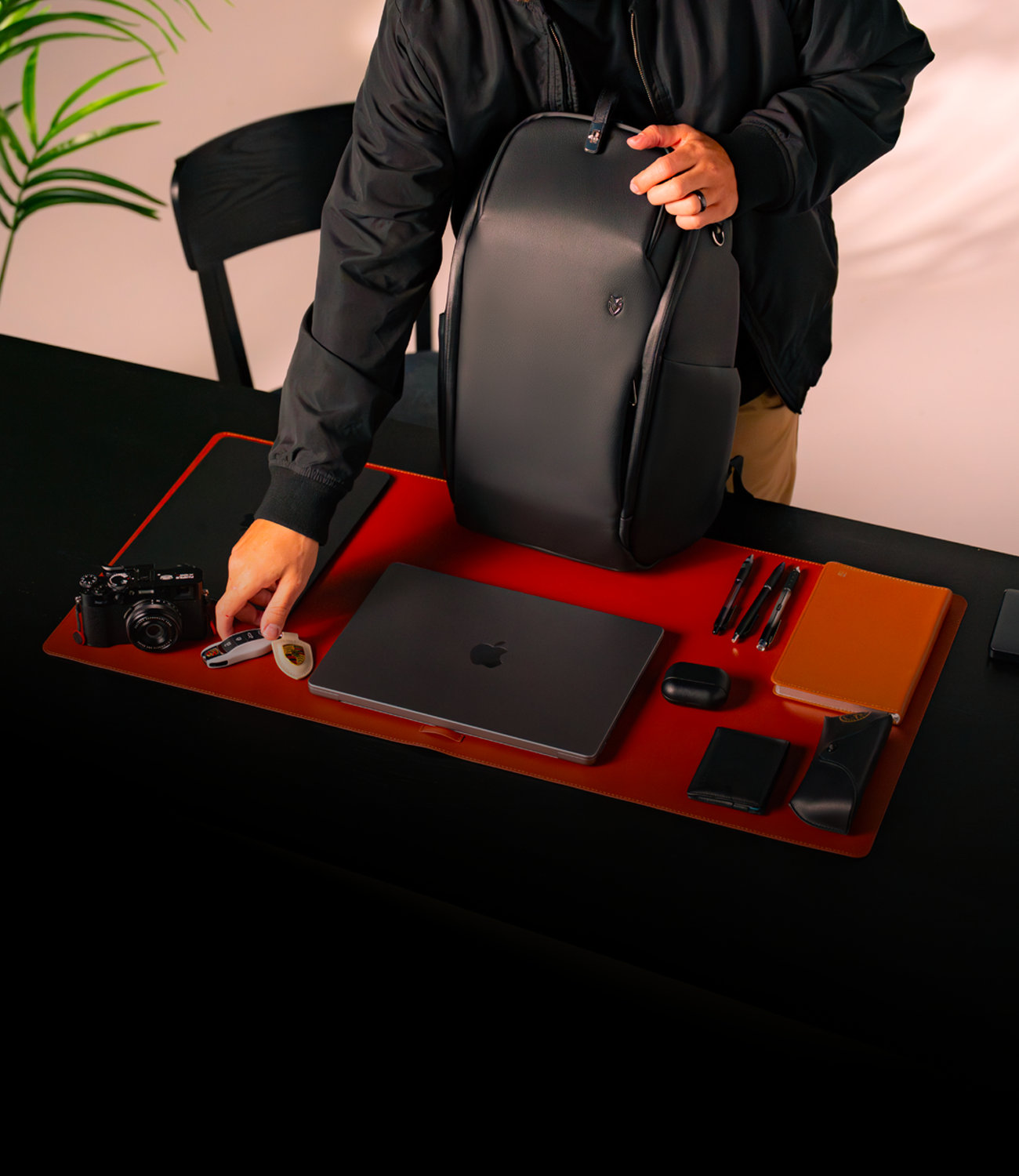 Black leather travel backpack on a desk with a man