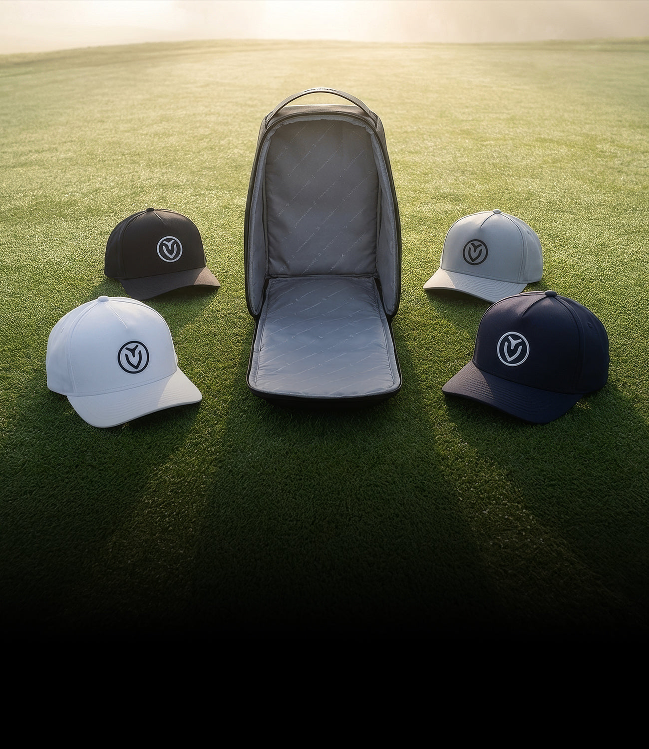 Voyager Headwear bag with four Vessel hats in grass field