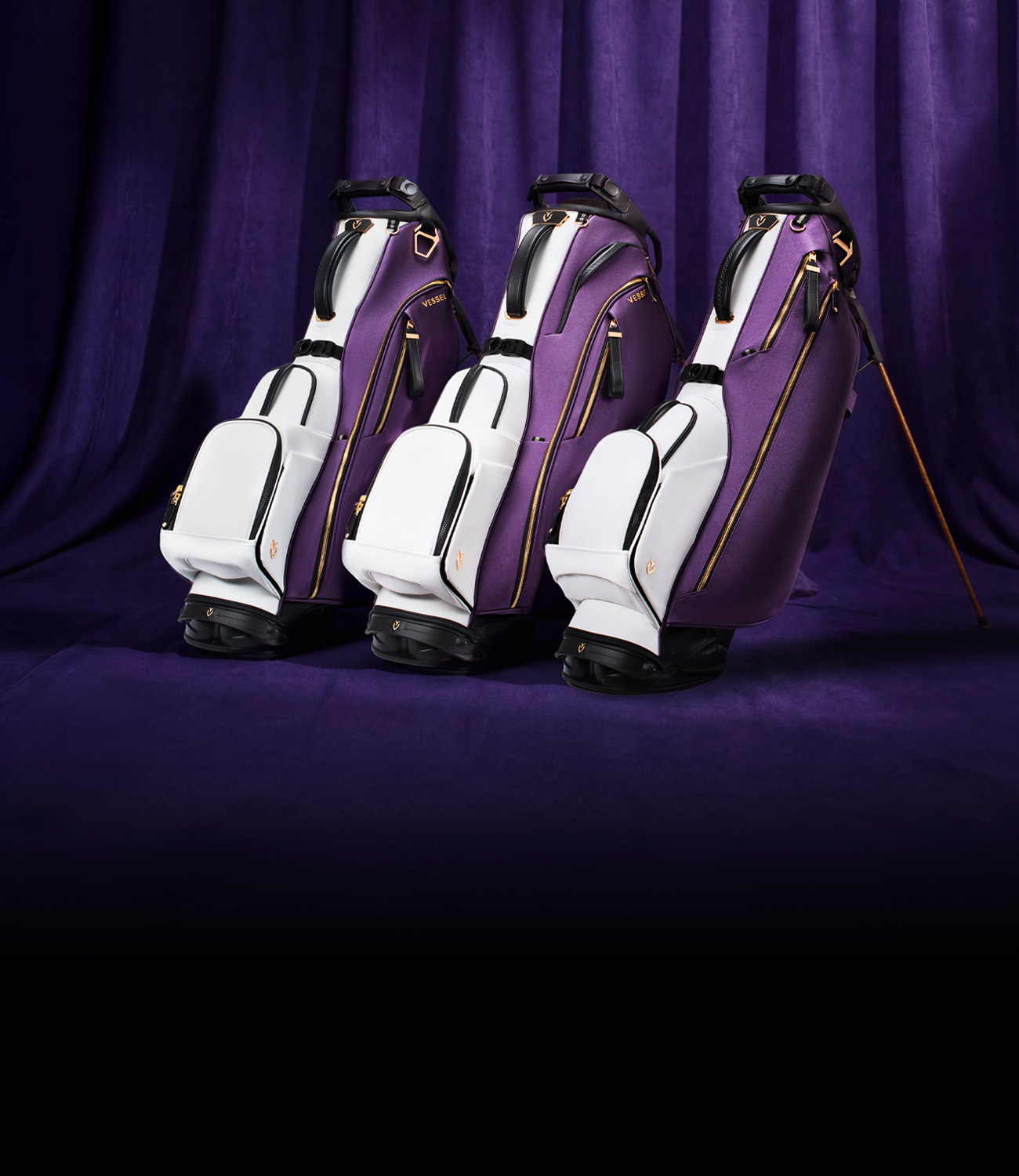 Three leather golf bags in front of a purple curtain