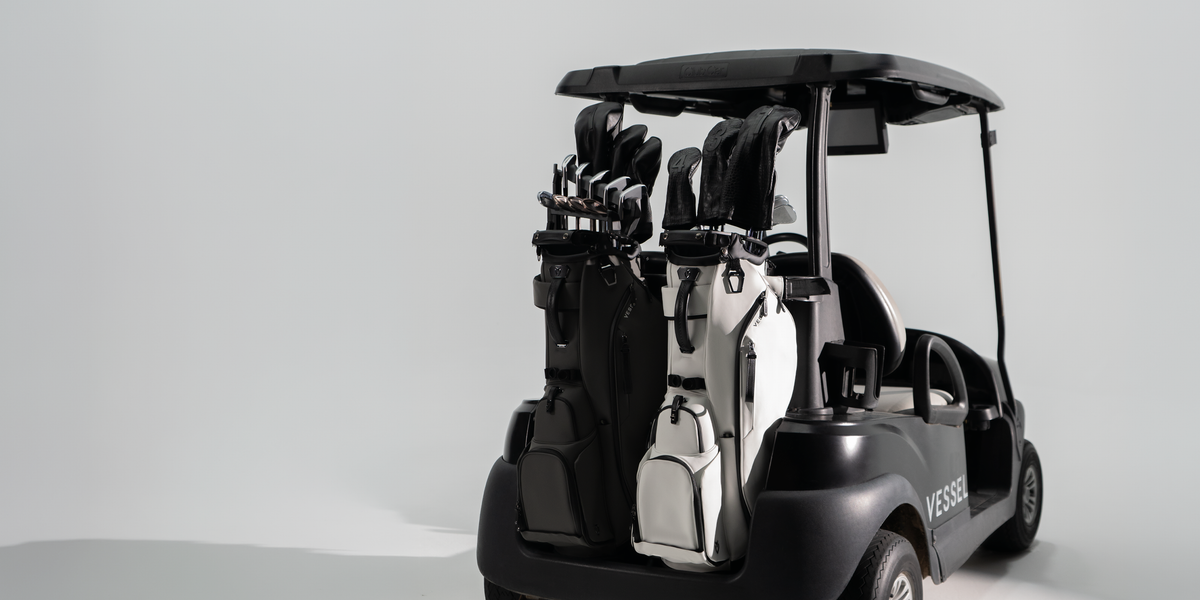 Two player VI Series stand bags on the back of a black golf cart