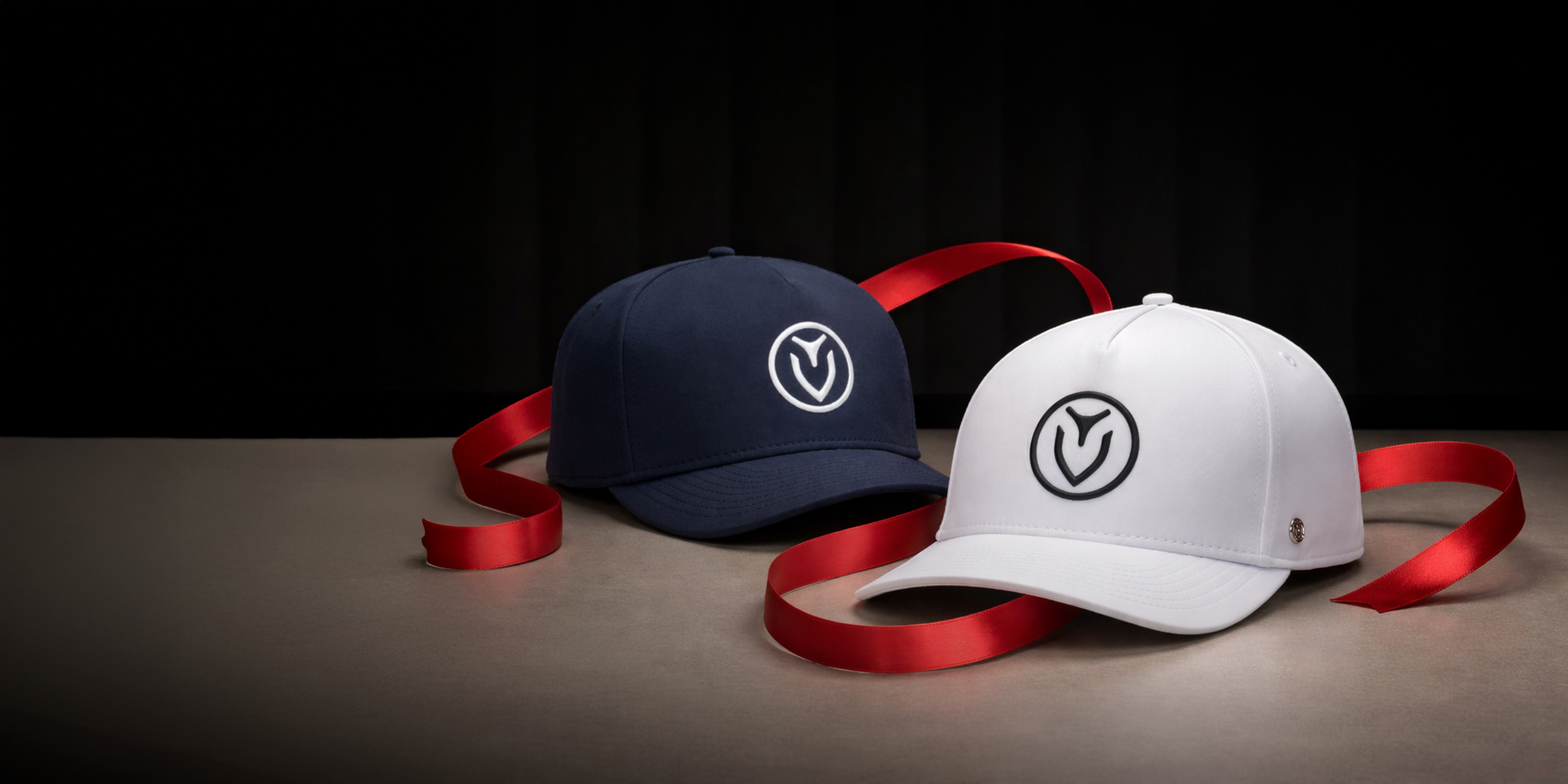 Navy hat and white hat wrapped loosely in red ribbon