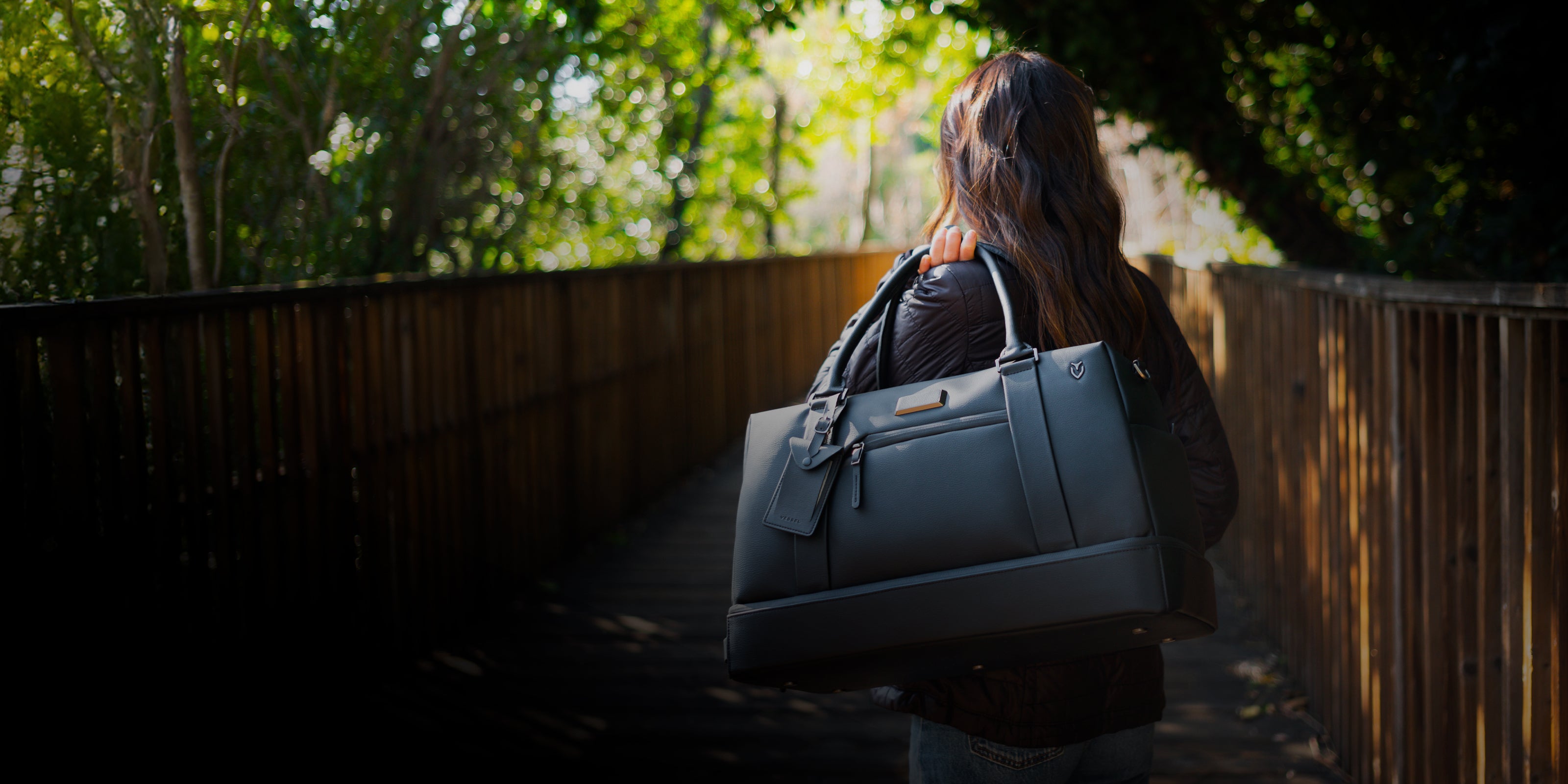 Woman with leather duffel bag over her shoulder