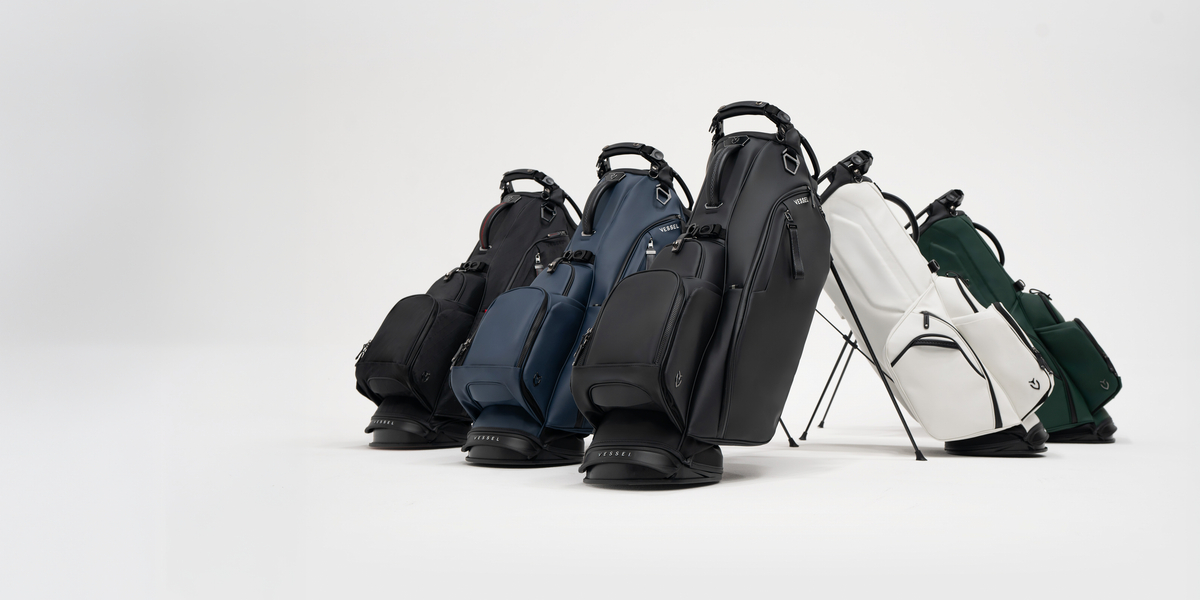 Five player VI stand leather golf bags lined up against a white background