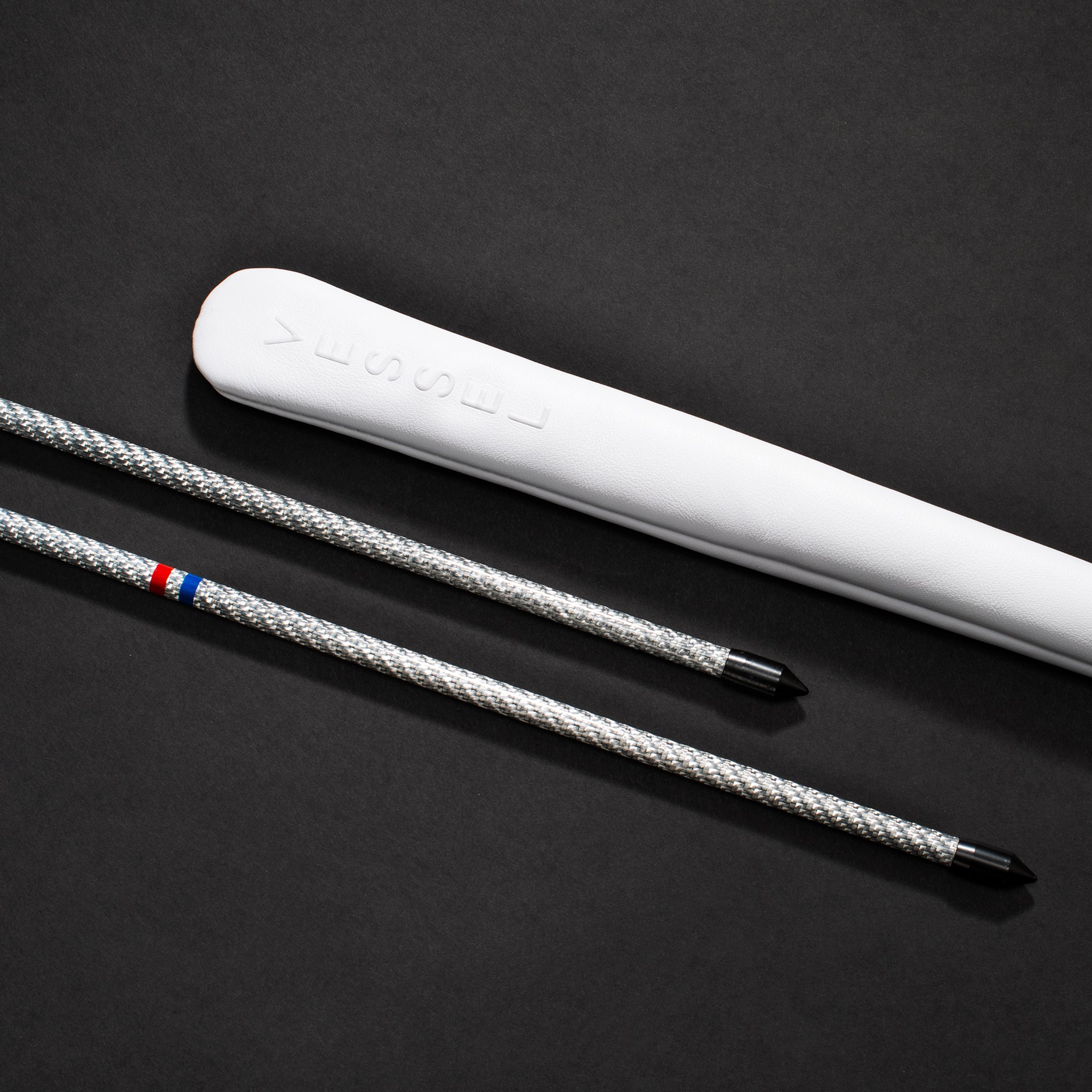 White Alignment Stick Embossé Cover next to silver alignment stick