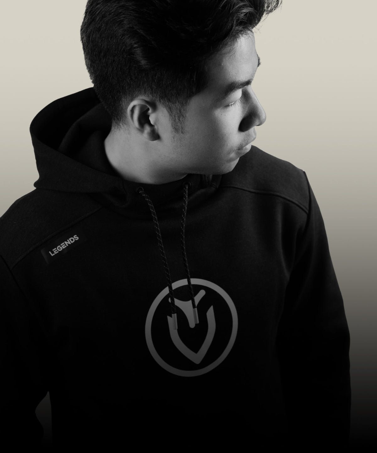 Person wearing a black hoodie with a Vessel logo on a plain background