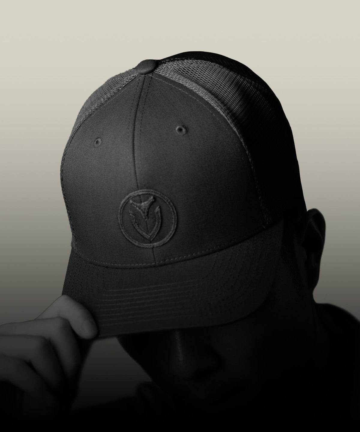 Person wearing a black Comfort Tech Trucker Hat on a neutral background