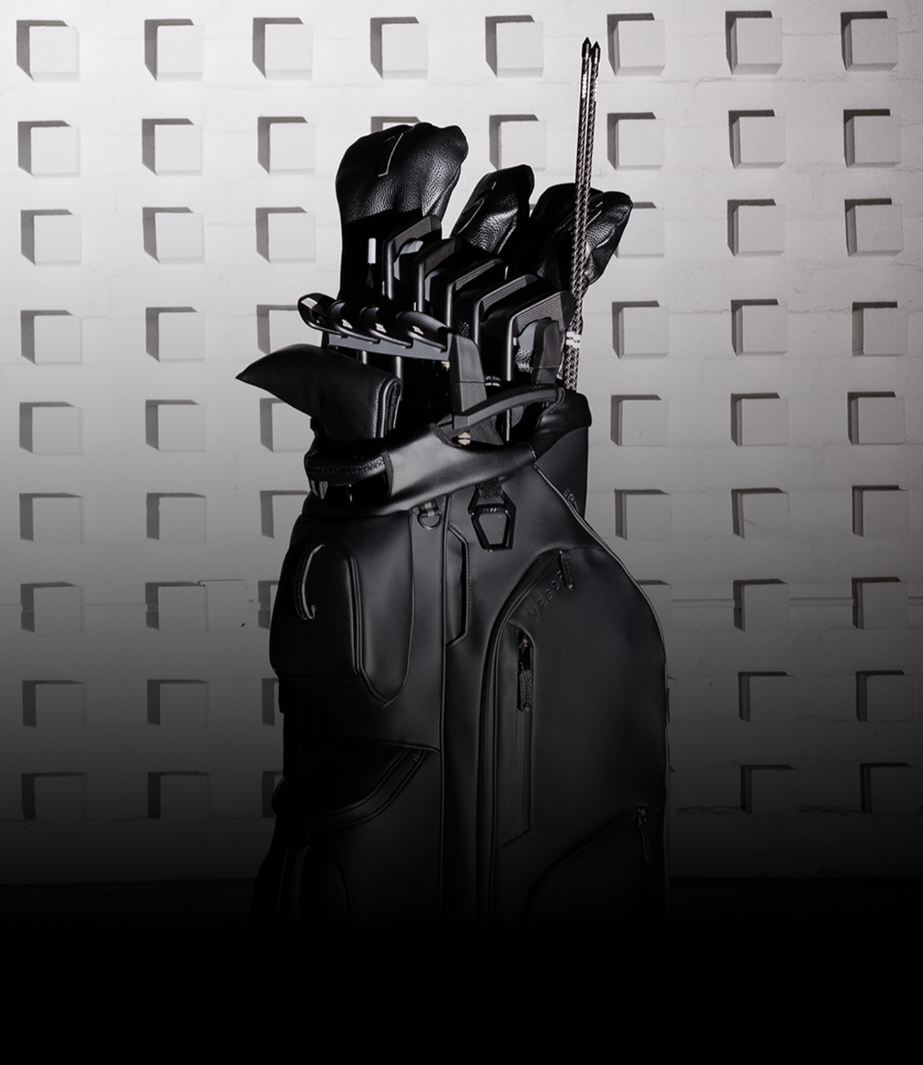 Sleek black golf cart bag with clubs in a club organizer. The minimalistic setting highlights luxury and sophistication.