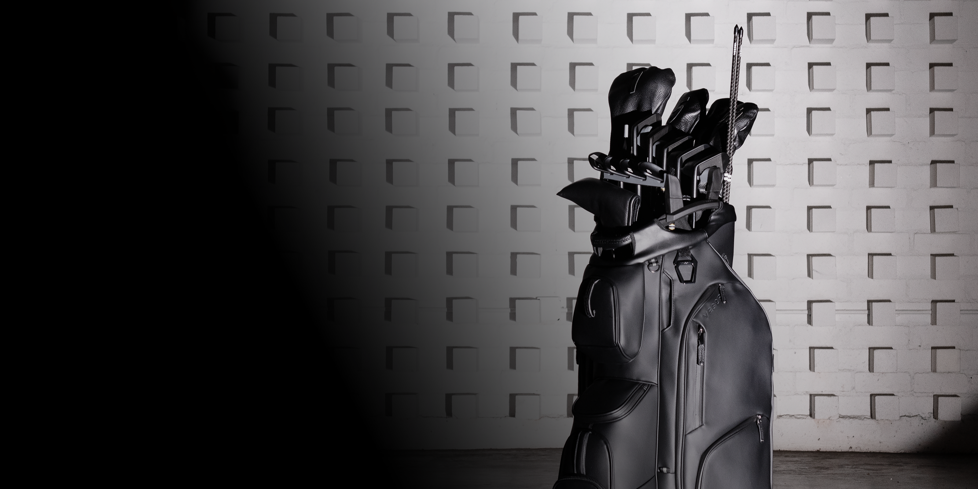 Sleek black golf cart bag with clubs in a club organizer . The minimalistic setting highlights luxury and sophistication.