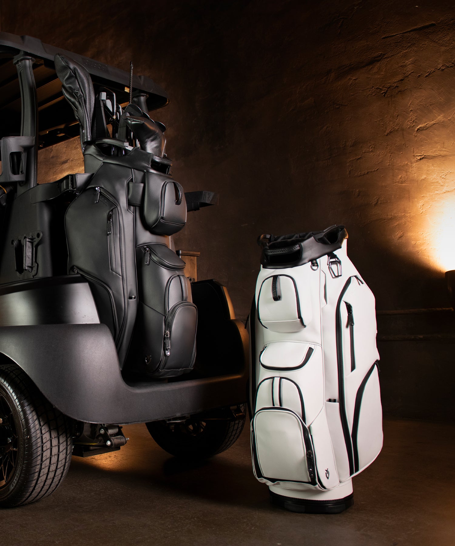 Two leather golf cart bags. The black bag has golf clubs and golf club headcovers in it