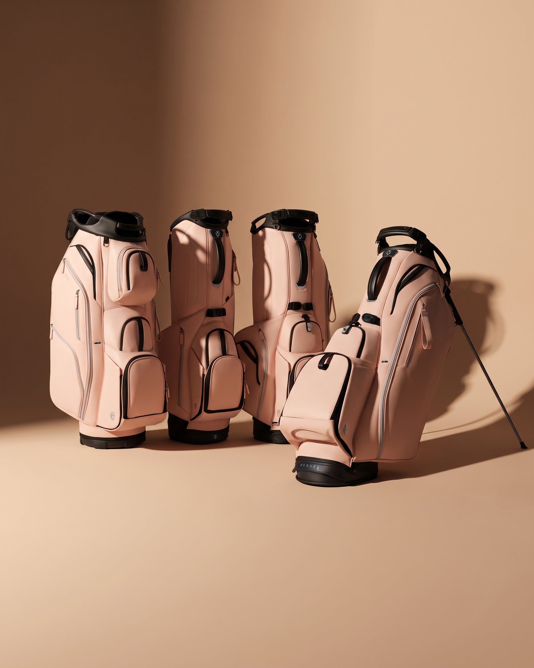 Four croc blush vessel golf bags against a blush background