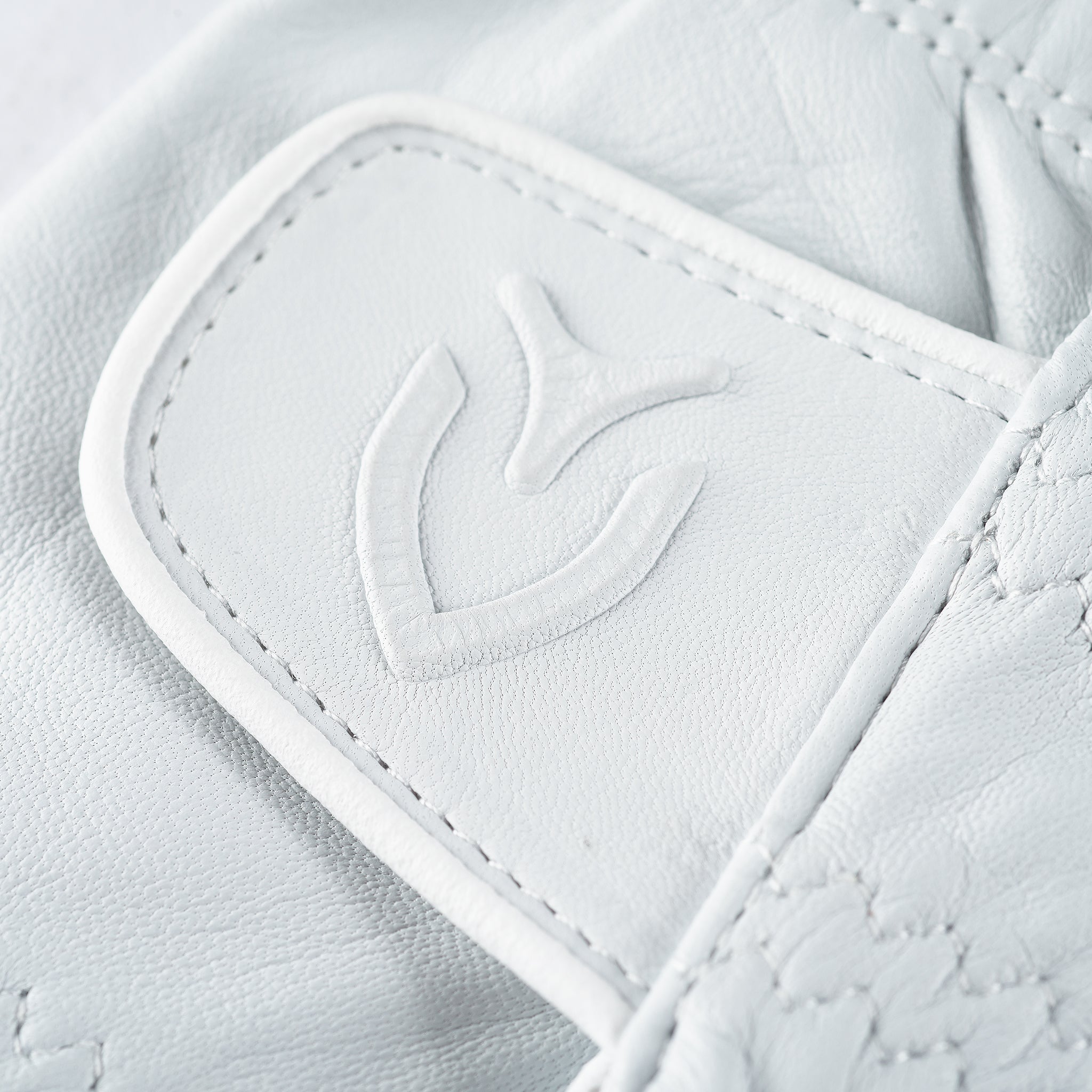 Close up of logo on velcro strap of Cadet Left handed white VESSEL Lux Golf Glove #hand_cadet left