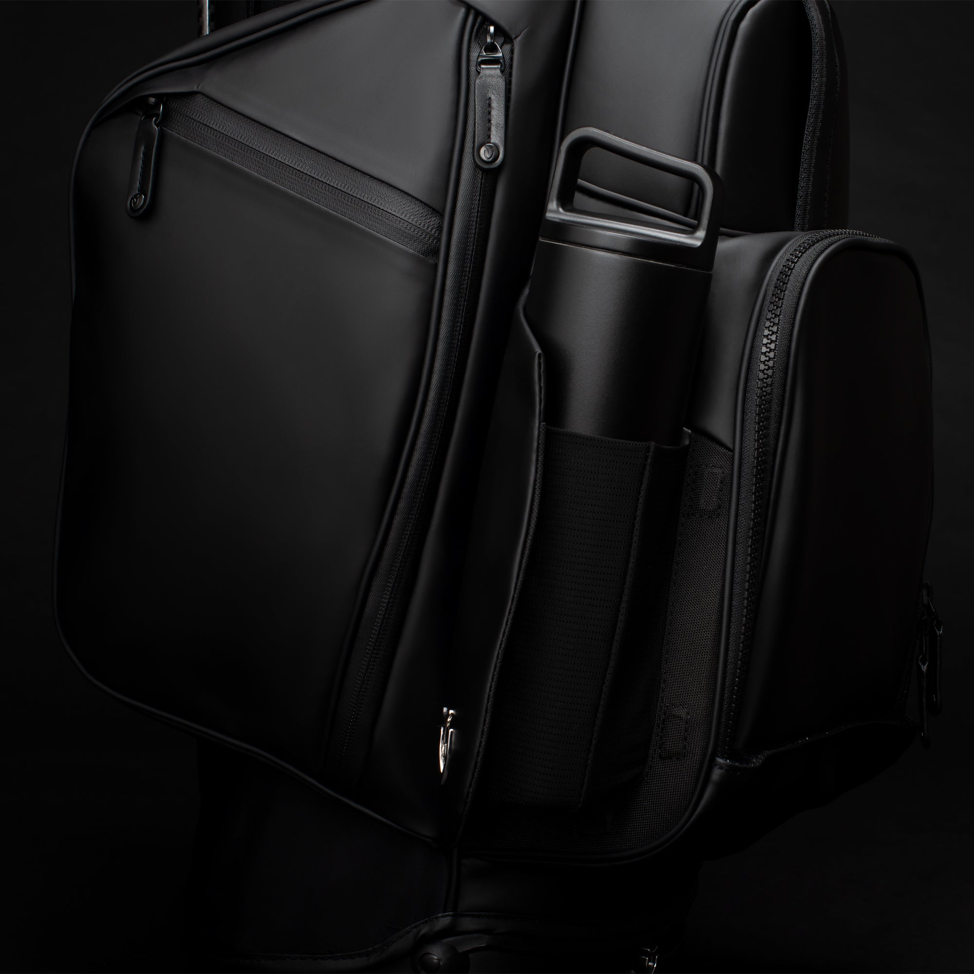 Close up of black water bottle in magnetic beverage pocket on black golf stand bag