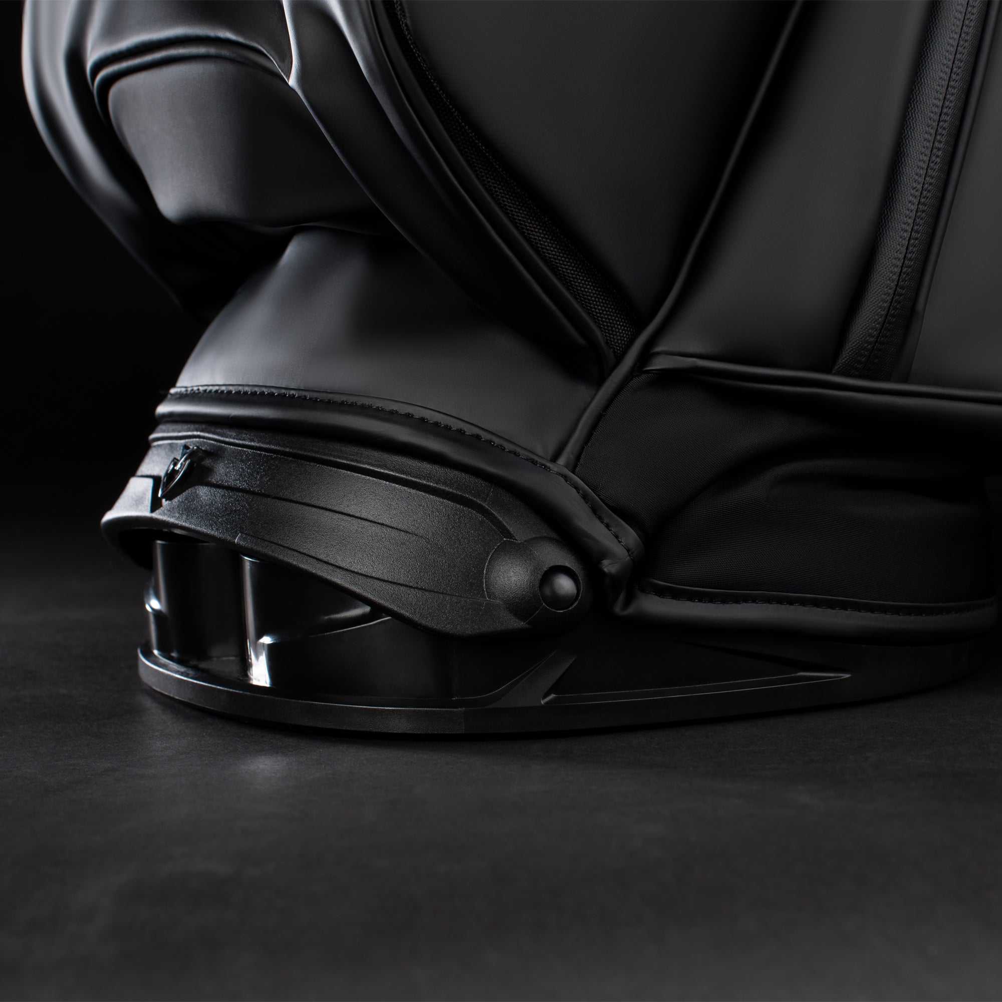 Close up image of the Rotator Base on a black golf bag in a black studio