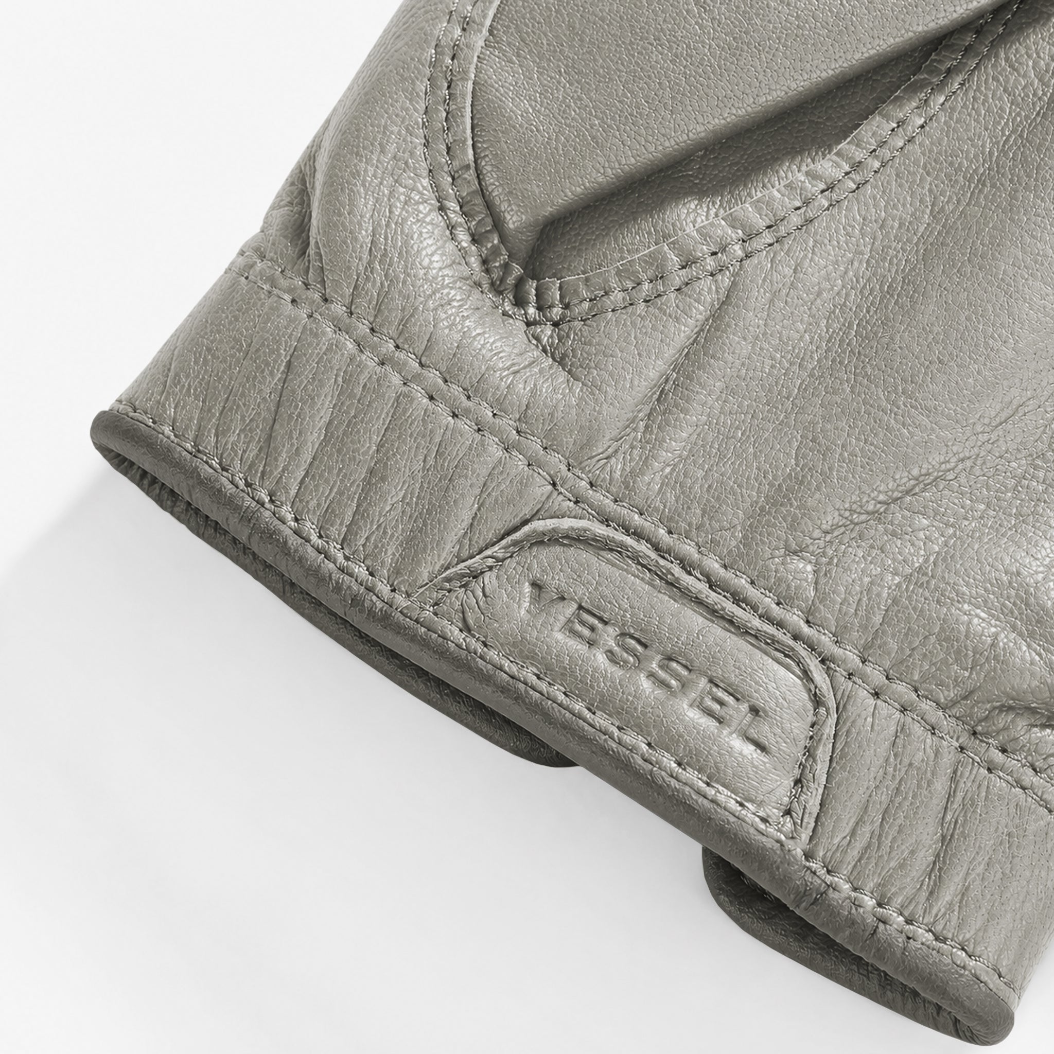 Close up of debossed logo on wrist of Left handed grey VESSEL Lux Golf Glove #hand_left