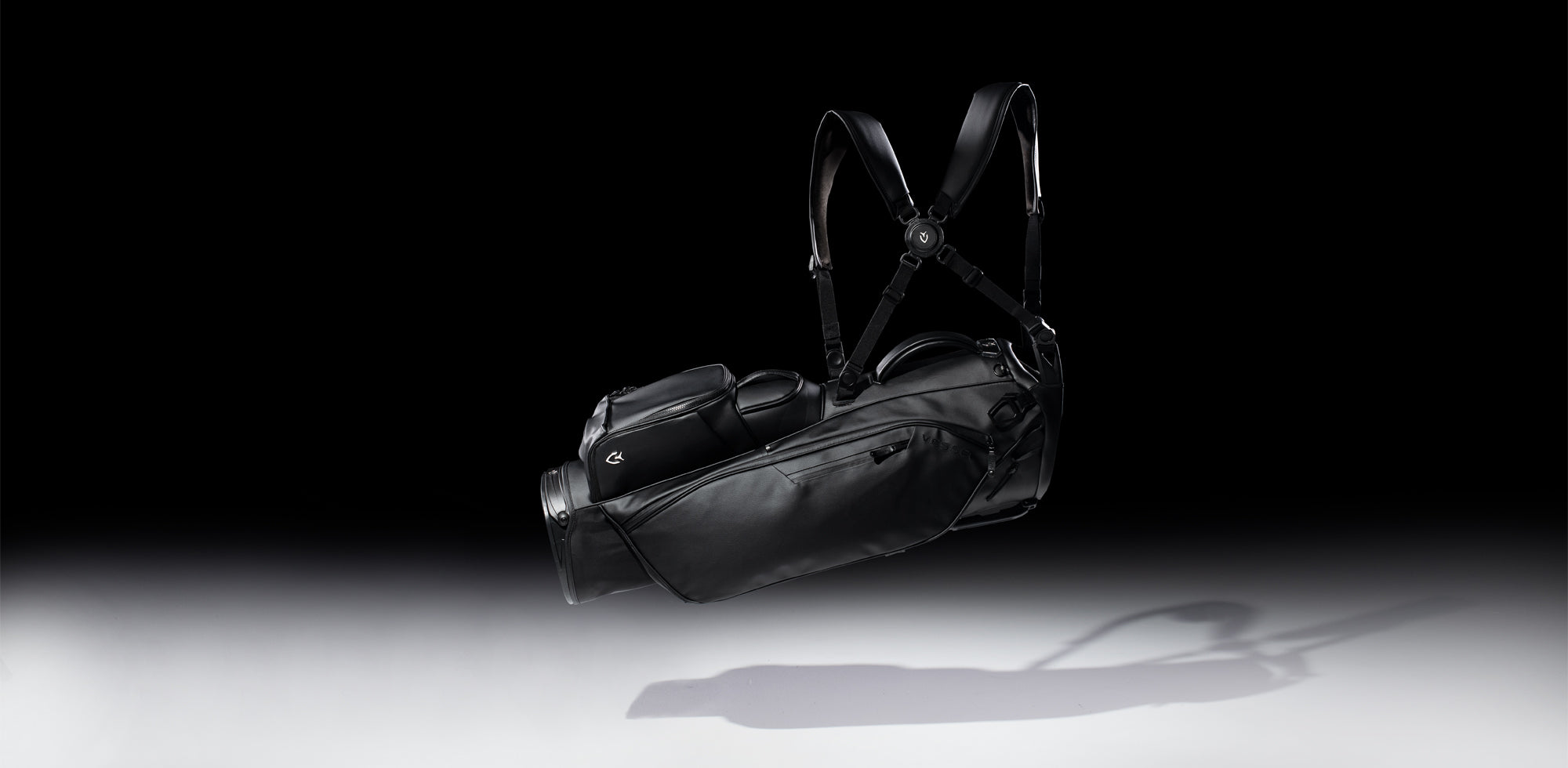 Black golf stand bag floating in a black studio