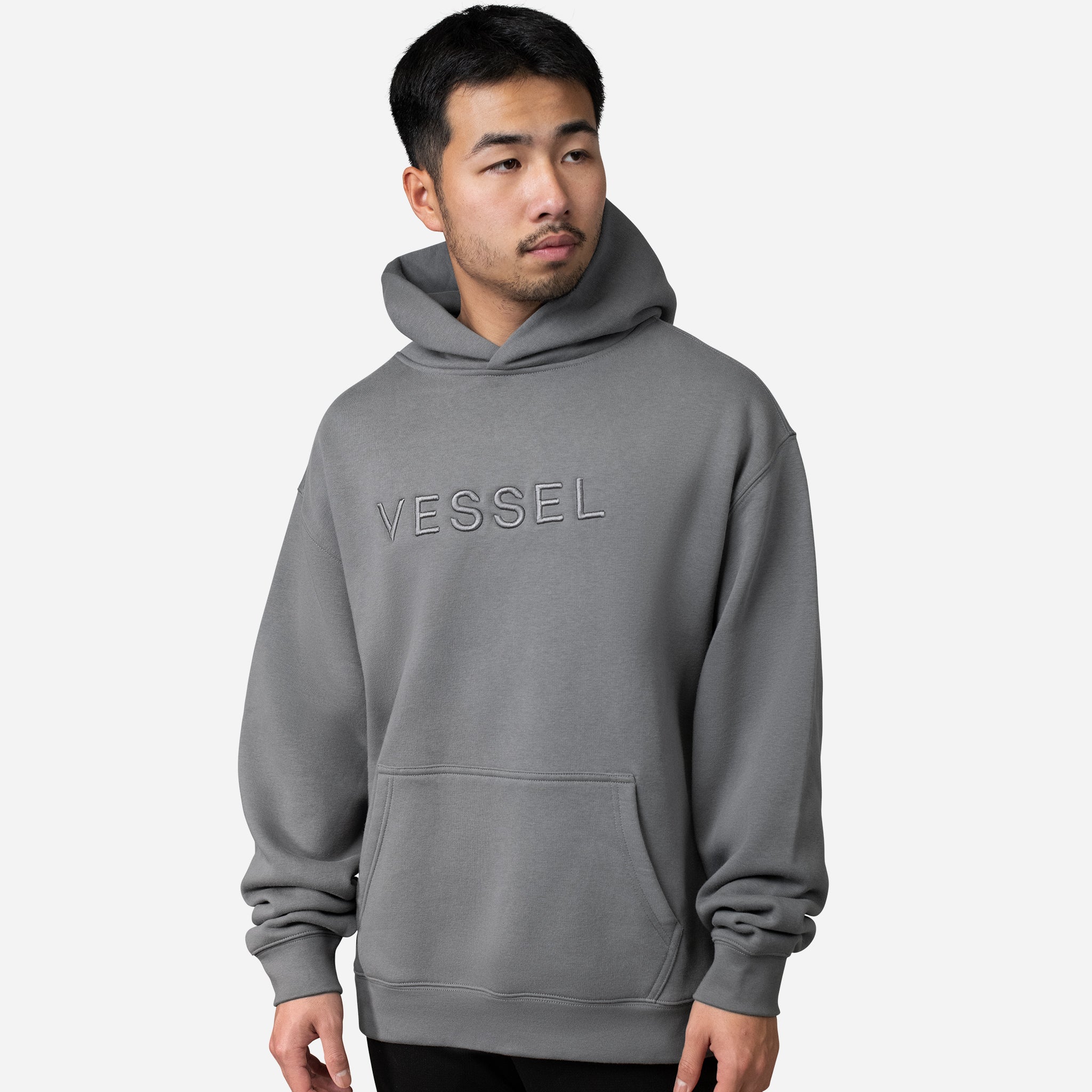 Man wearing grey VESSEL Hoodie #color_grey