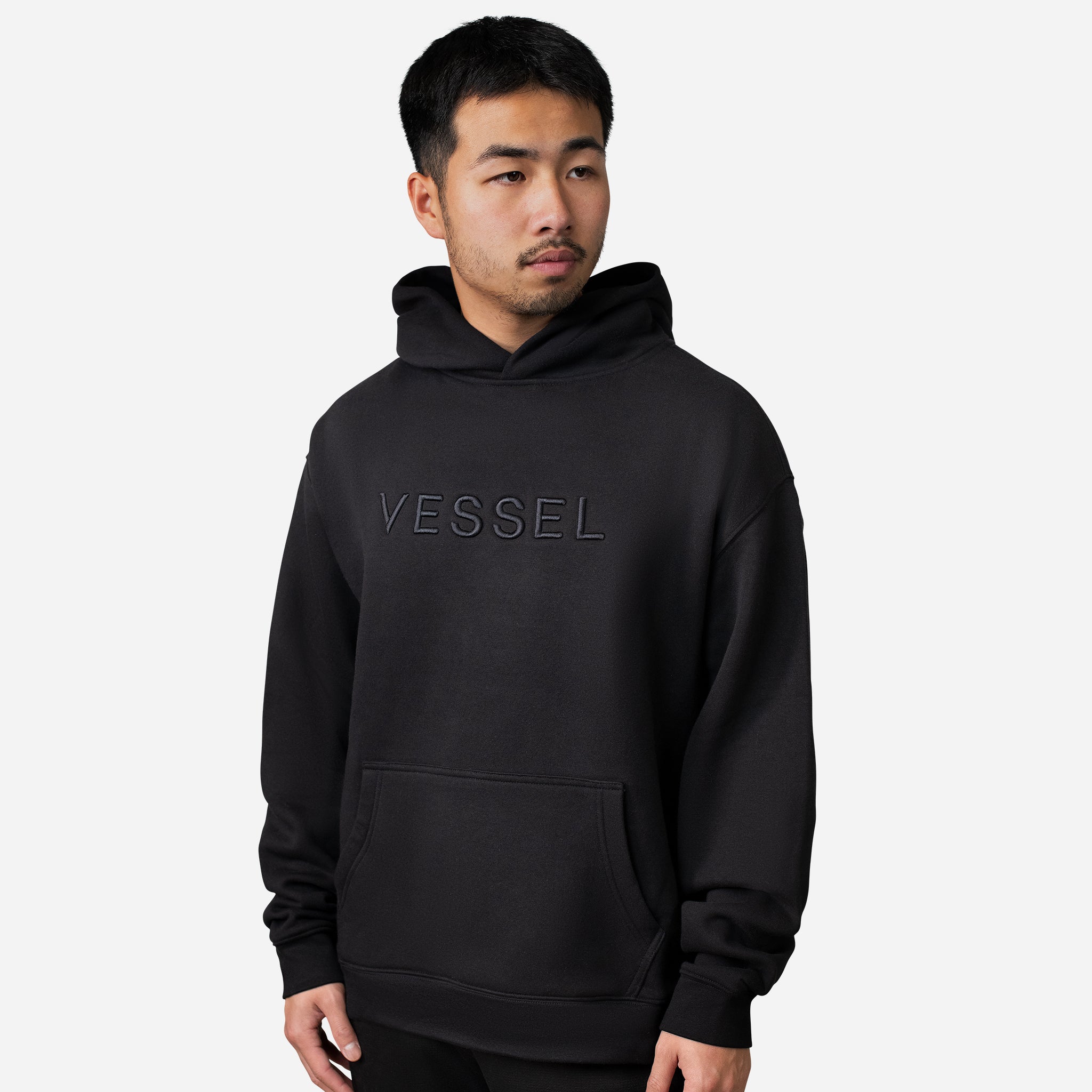 Man wearing black VESSEL Hoodie #color_black