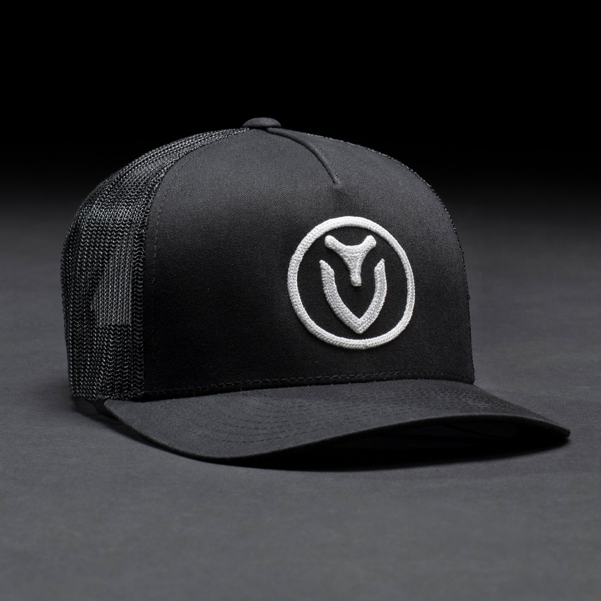 A black VESSEL trucker hat in a black studio